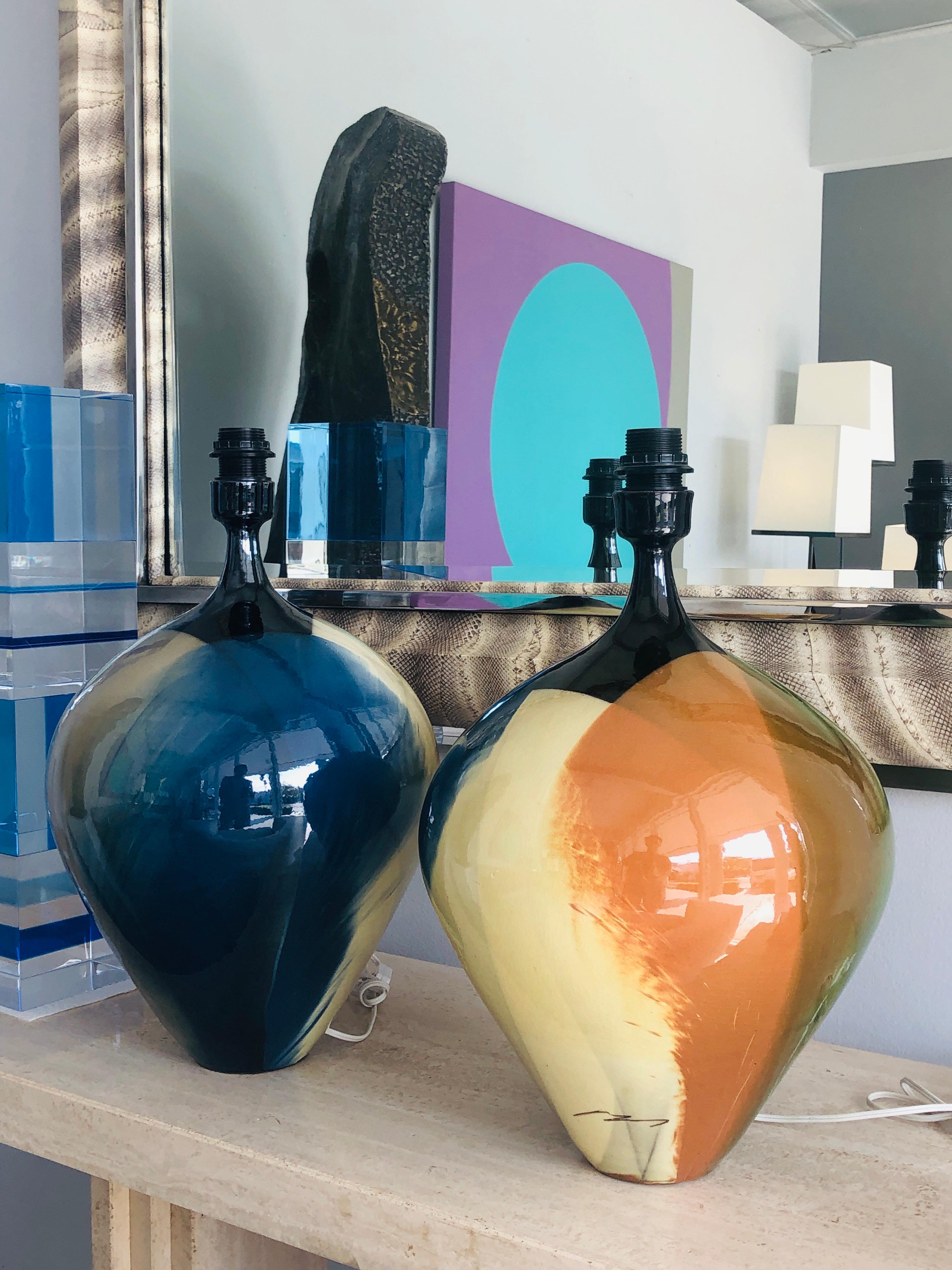 A pair of large and colorful ceramic lamps. Both Signed illegibly. Note how even though the design is almost identical, the front of the lamps is random, quite refreshing.