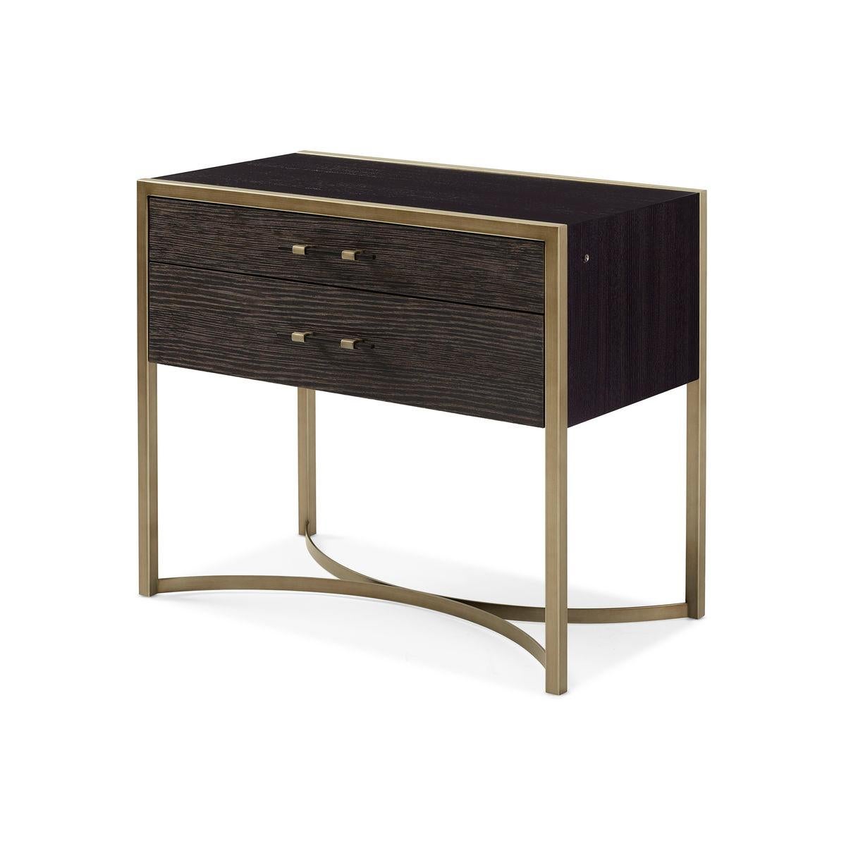 The clean-lined profile is paired with a shapely metal base created by two half circles. With its medley of cerused oak, black stained Ash and bronze metallic finishes, this bedside essential feels both classic and style-forward. Two drawers