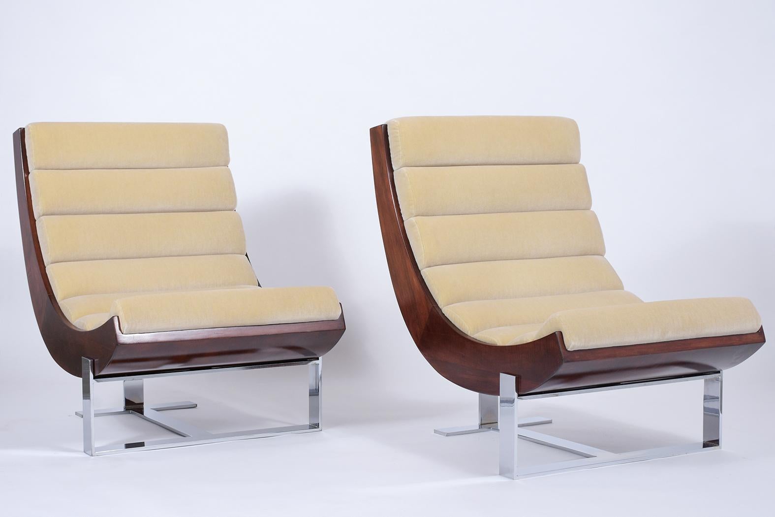 An extraordinary pair of midcentury lounge chairs that are handcrafted out of steel and maple wood combination and features new dark red mahogany color with a lacquered. These club chairs are also professionally reupholstered in a new beige mohair