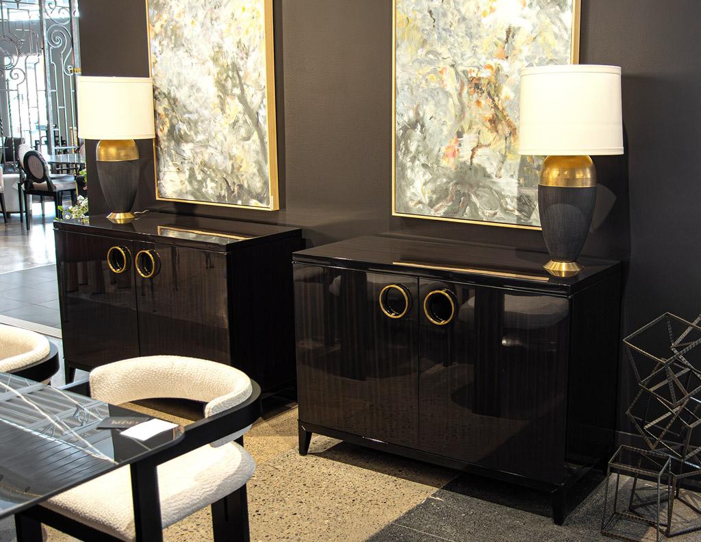 With its modern styling, traditional inspirations, and hand polished high gloss finish, this exquisite commode cabinet is a beautiful addition to any home. Crafted in the USA from the finest walnut woods. Unique brass ring hardware adds a touch of
