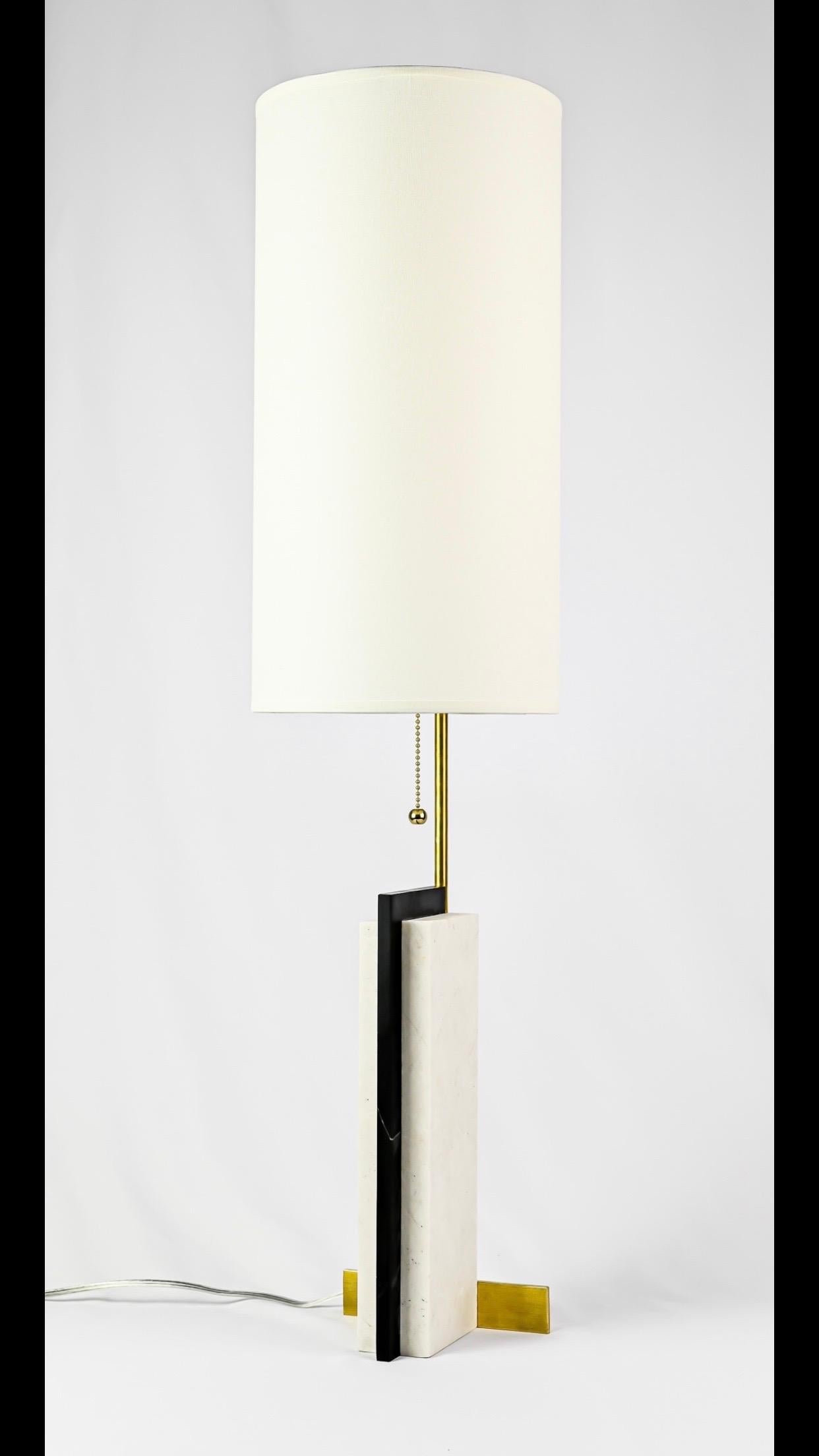 Elegant and timeless pair of modern craftsman table lamps in marble and brass by Keith W. Gregor.

The pieces are constructed of 2 white Carrara marble rectangular pieces sandwiched around a piece of black marble that are supported by solid brass