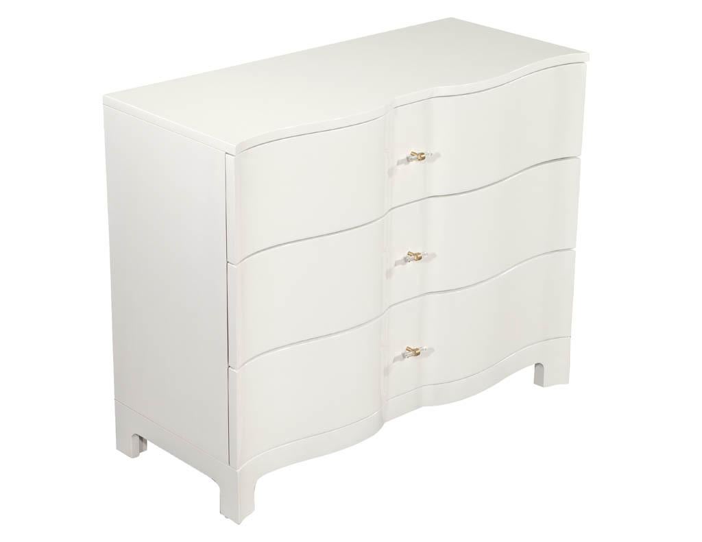 Pair of modern cream chests with curved fronts. Curved three drawer chests finished in a hand polished cream lacquer with brass and acrylic handles. Drawers are lined with soft black velvet material.

Price includes complimentary scheduled curb