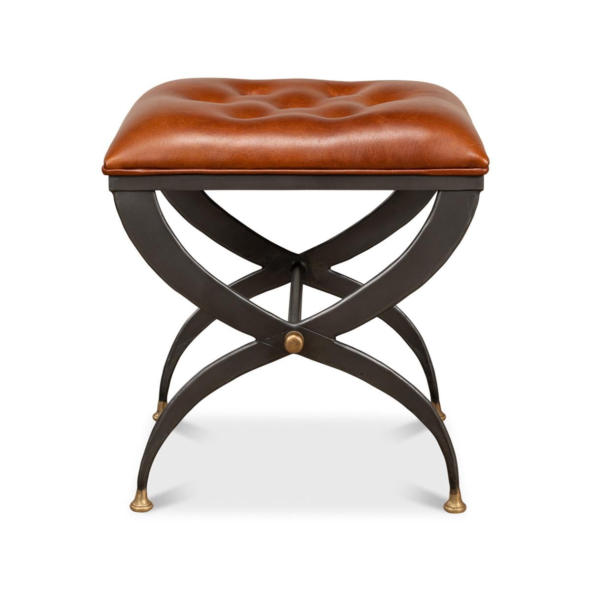 A Modern curule stool with a button tufted leather cushion seat above a pewter-finished iron curule form base with gilded accents.

Dimensions: 20