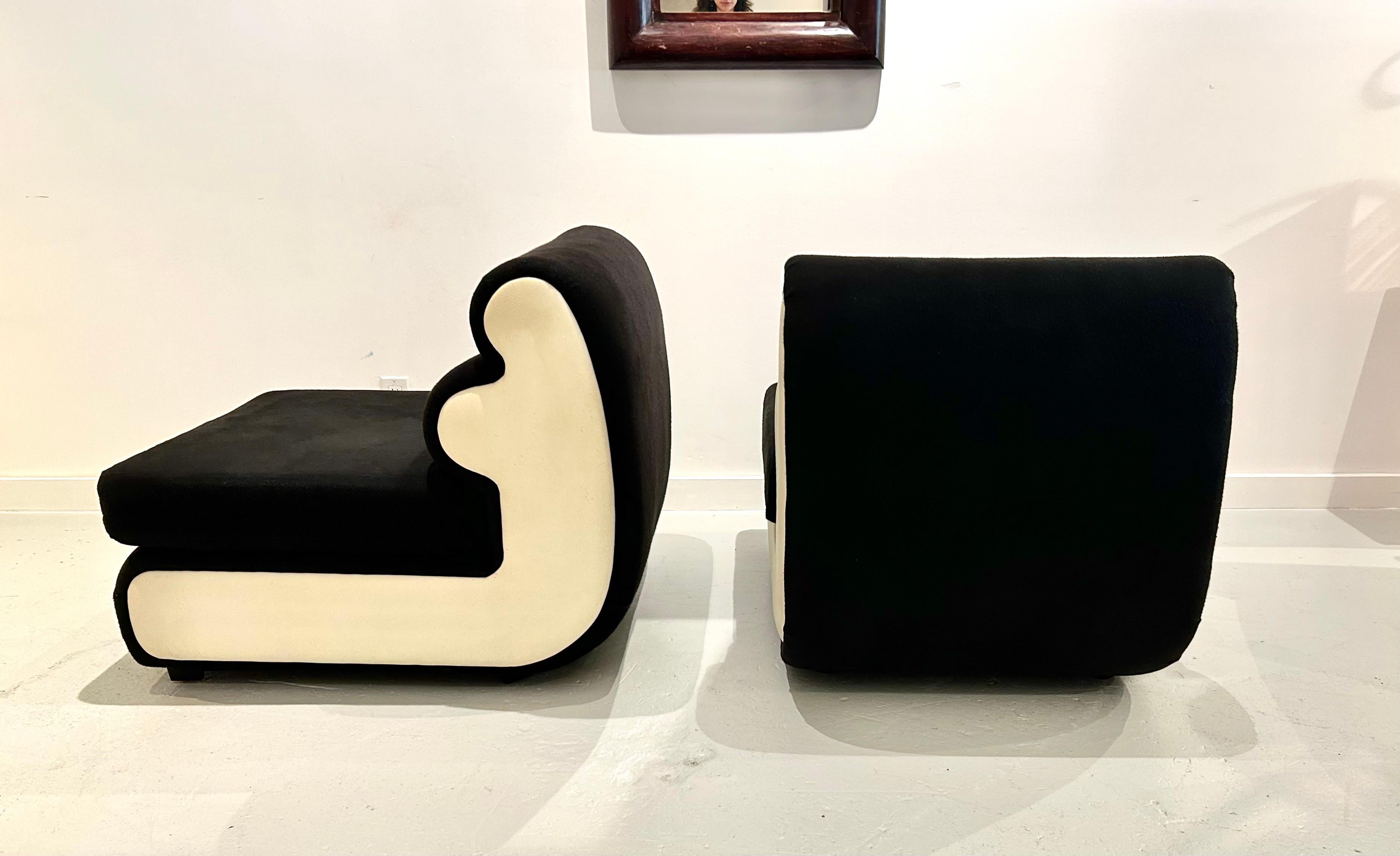 Paire de chaises de salon conçues avec un dossier à double courbure actuellement revêtu d'un similicuir de couleur crème et d'un tissu mélangé de coton noir, contrastant bien et accentuant les lignes des chaises. Chacun d'entre eux est doté d'un