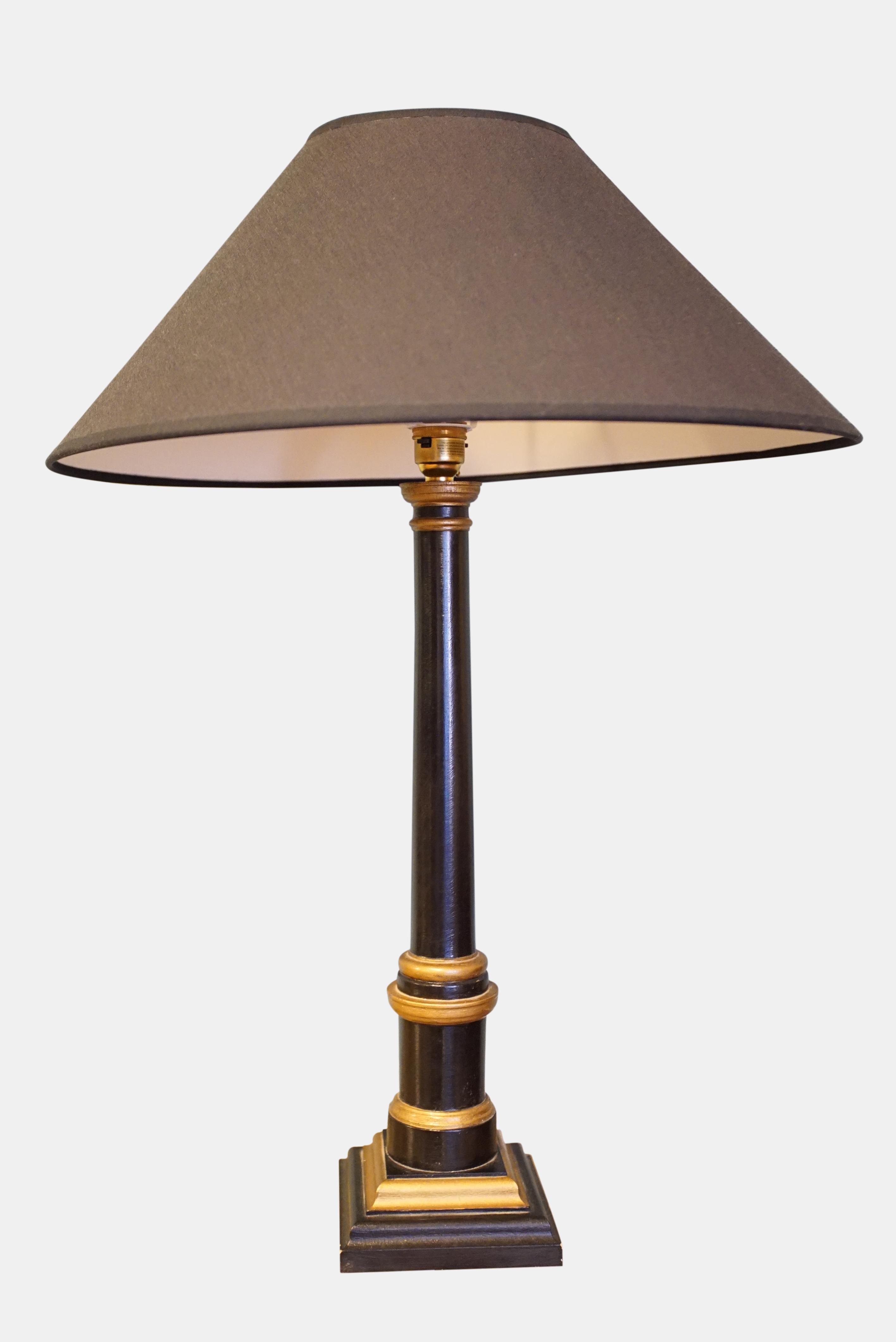 A pair of modern turned wood, ebonised and parcel-gilt table lamps,

circa 1980.