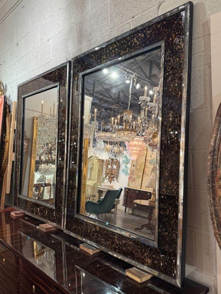 Great pair of modern high-style Eglomise border mirrors. Eglomise border mirrors feature hand-applied gold or silver leaf behind glass, creating luminous frames that shimmer with depth and texture. 42w x 54h 