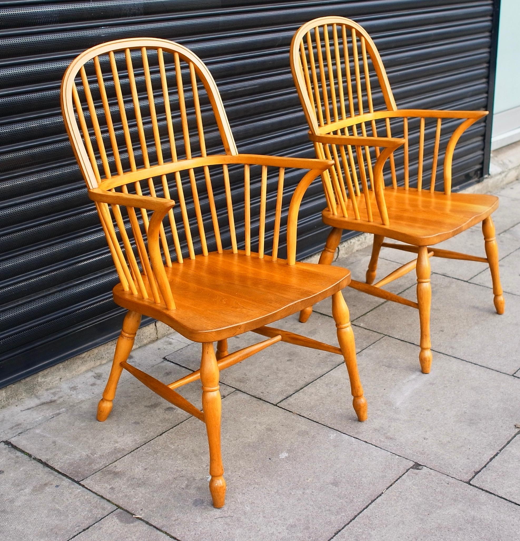 A stylish pair of pine framed late 20th century windsor chairs on classic turned legs. These chairs are in very good vintage condition having been cleaned and polished, with all joints inspected and found to be sturdy.