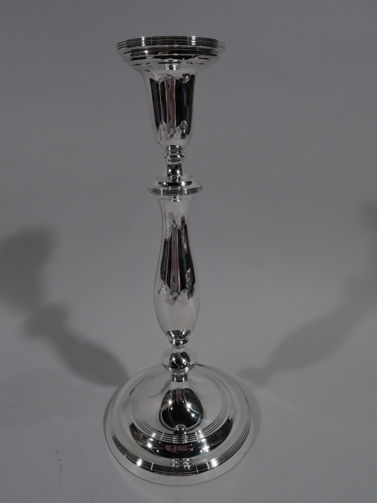 Pareja de candelabros Modern Georgian de plata de ley. Fabricado por Blackinton en North Attleboro, Massachusetts, hacia 1940. Fuste de balaustre estriado sobre pie abombado. Reed. Una interpretación voluptuosa de una forma tradicional. Totalmente