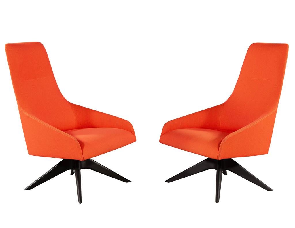 Pair of Modern High Back Swivel chairs by Andreu World. Featuring textured burnt orange fabric with oversized seat and tall back. Able to pivot left and right, sitting atop a black 4 legged pedestal. A perfect chair for an office or lounge