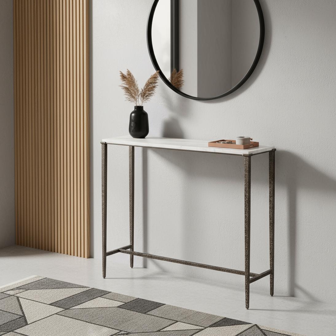 Featuring a sleek rectangular silhouette, the console is topped with a refined slab of white marble that brings elegance and lightness to the design. Its slender iron frame is finished in antique nickel, highlighted by a hammered texture that adds