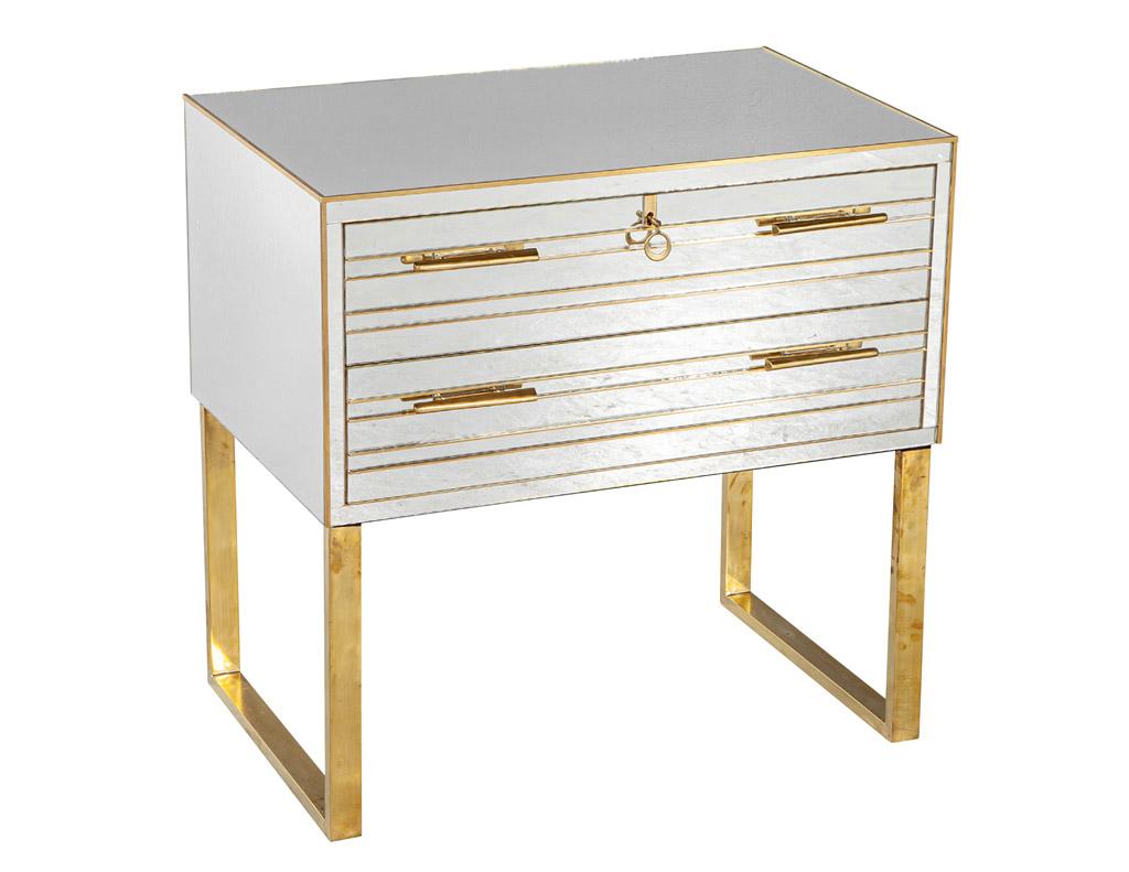 This beautiful pair of modern Italian brass and mirror nightstand chests are the perfect addition to any bedroom. They are made of all mirror and feature two drawers with custom brass hardware and brass inlay. The sleek brass legs add an elegant