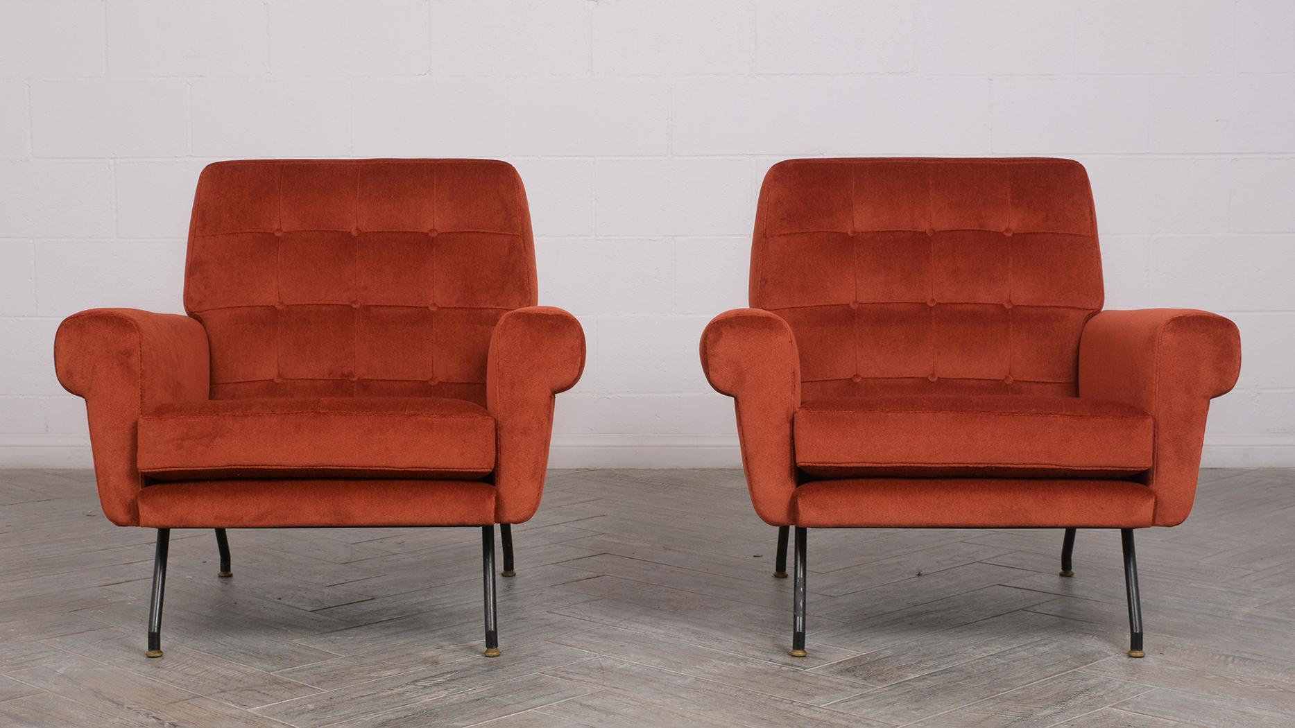 This pair of 1960s Modern style lounge chairs have been completely restored. These comfortable chairs have been professionally reupholstered in a orange red colored mohair fabric with tufted detail. The legs are made from wrought iron and finished