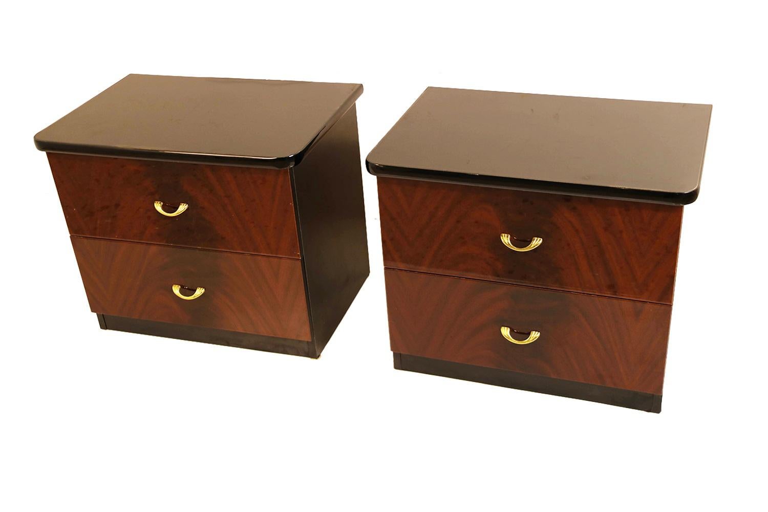 An attractive rare pair of beautifully matched early 20th century modern mahogany nightstands, tables. A fantastic pair of nightstands featuring crotch mahogany face and framed in painted black sides with polished black lacquered tops. Each includes