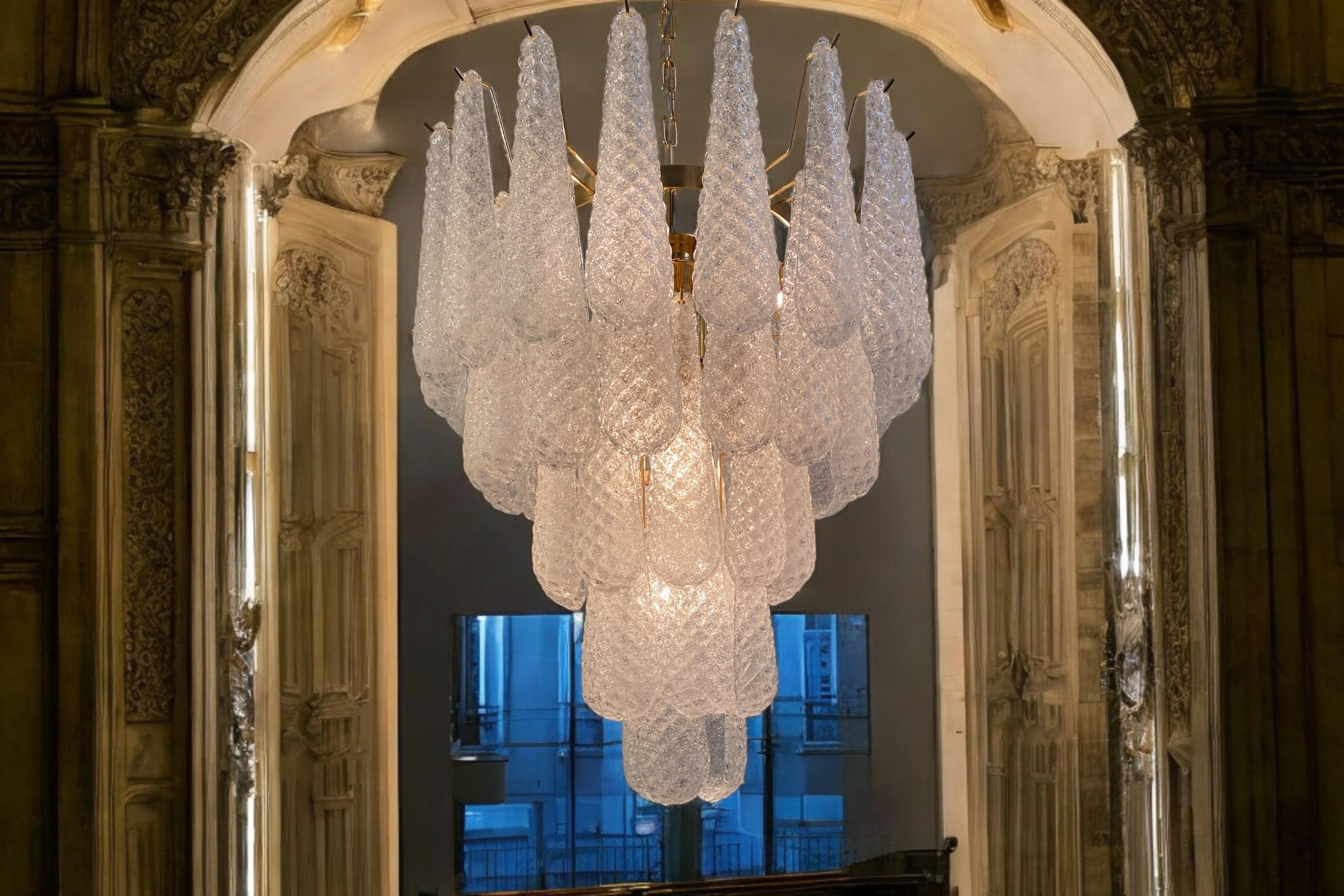 Fine Italian Murano chandelier made by 52 glass petals (transparent crystal, smooth outside, with
crystal powder and then rough inside.) with a brass frame.
Period: 1970s-1980s.
Dimensions: inches (75 cm) height without chain; 26 inches (66