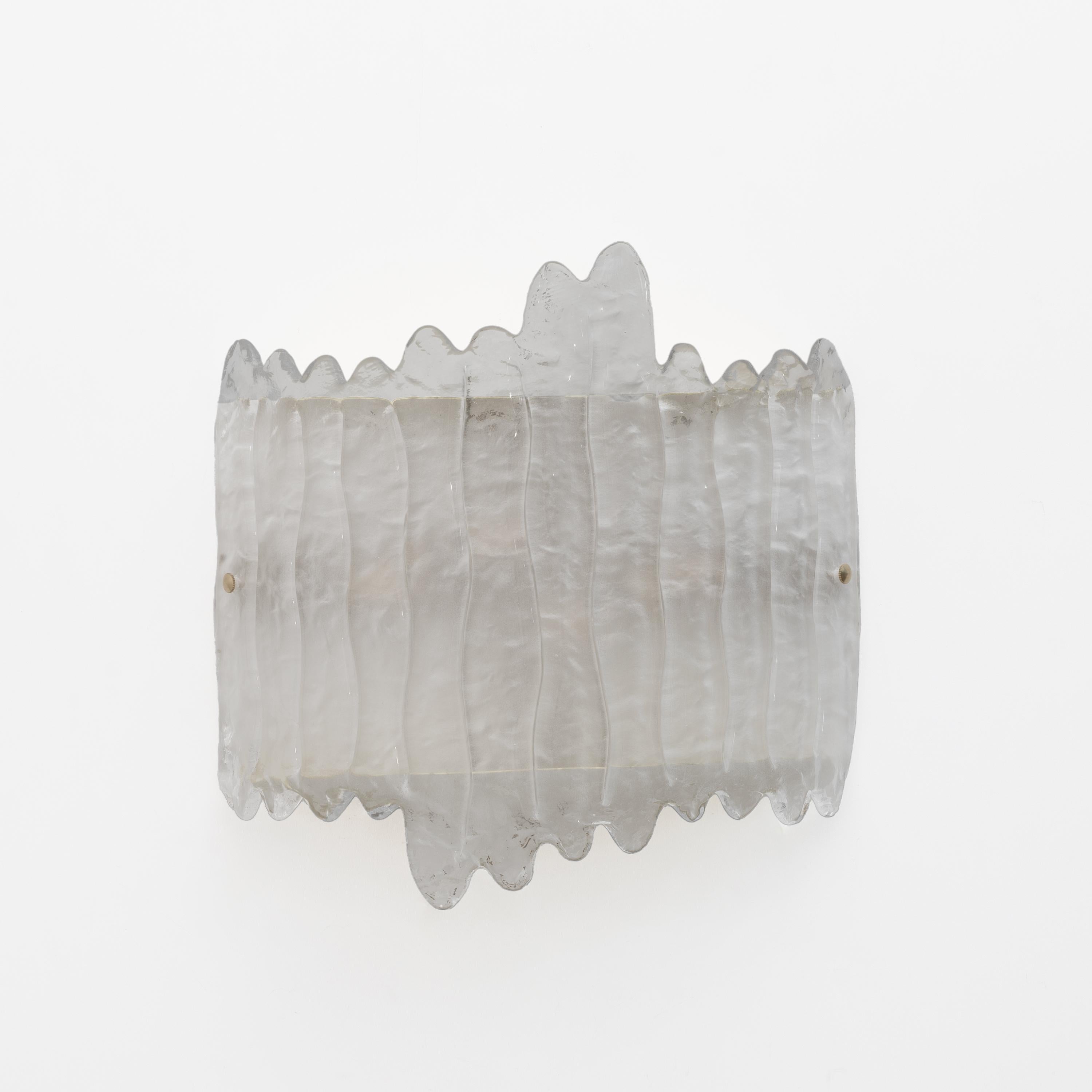 Stunning Murano glass and brass lamps, textured glass, made even more beautiful by the brass base. The wall lamps consist of a brass and metal frame that attaches to the wall with dowels and a large curved sheet of crystal-colored Murano glass that