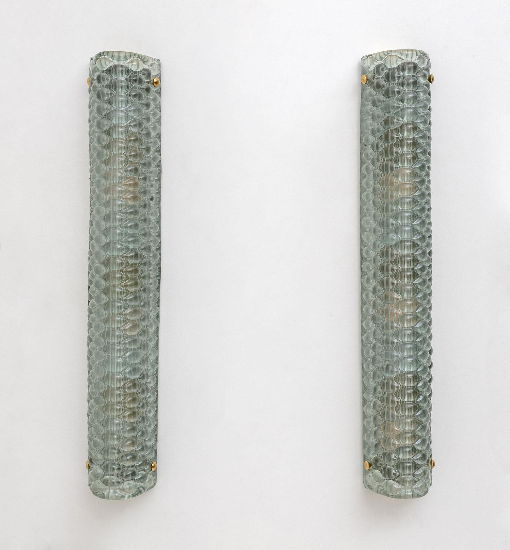 Pair of vintage wall lamps in green structured Murano glass, produced by Murano masters. These are high quality and give off a nice warm glow. Each wall light contains three medium base bulbs and is also wired to meet US standards.