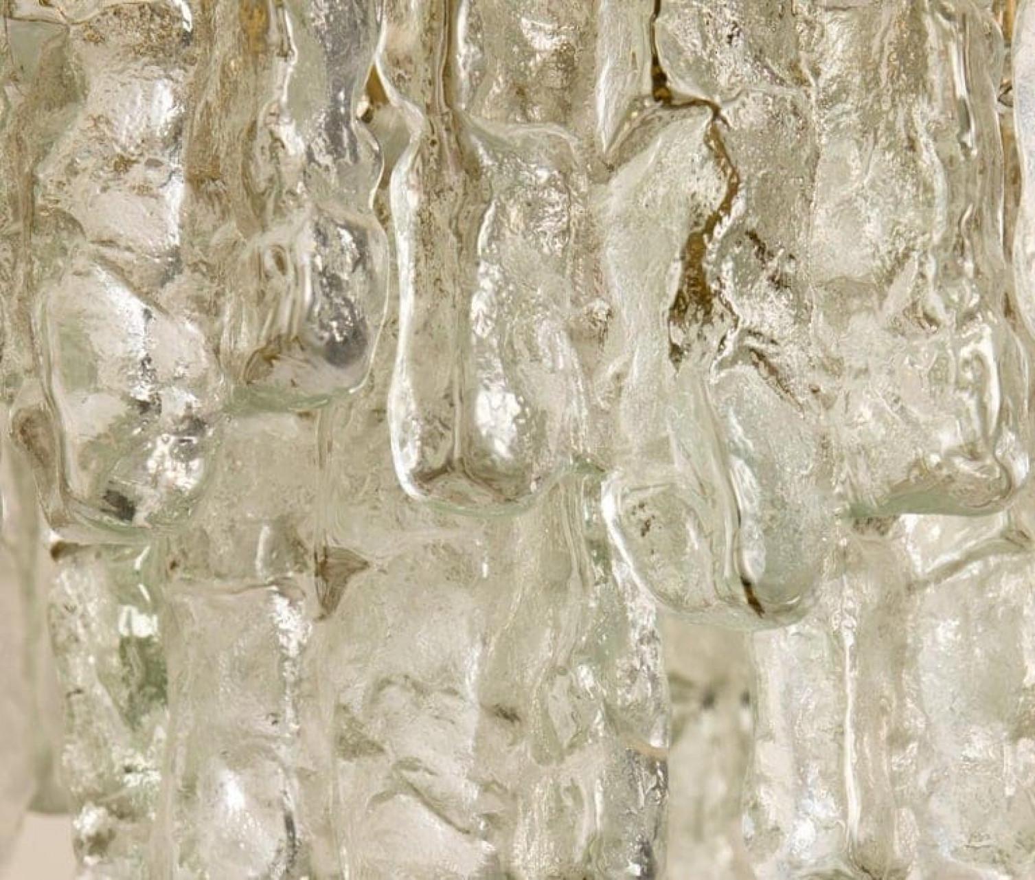 Ein Paar schöne und elegante moderne Messinglüster, hergestellt von Kalmar Austria in den 1970er Jahren. Wunderschönes Design, jeder Kronleuchter hat zwei Schichten von extrem stilvoll strukturierten massiven Eisglasscheiben (18 Stück), die an ihm