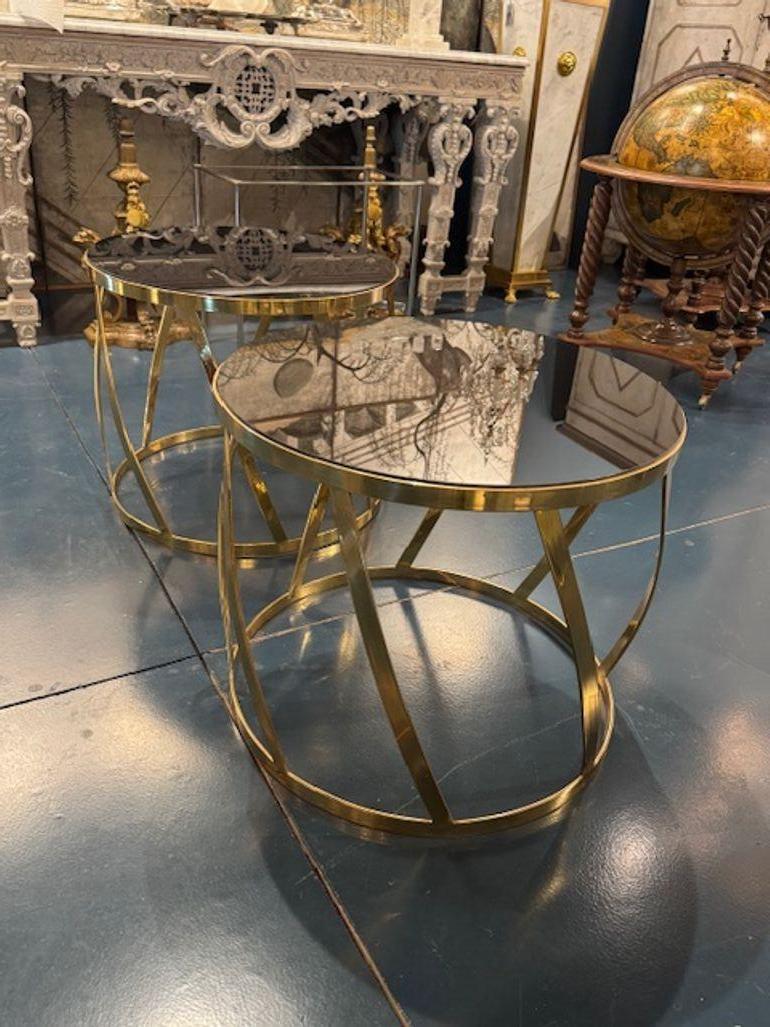Questi tavolini in vetro e ottone dal design moderno di Karl Springer sono un'aggiunta di stile a qualsiasi casa. L'elegante base in ottone e il piano in vetro nero creano una combinazione straordinaria e aggiungono un tocco di eleganza e