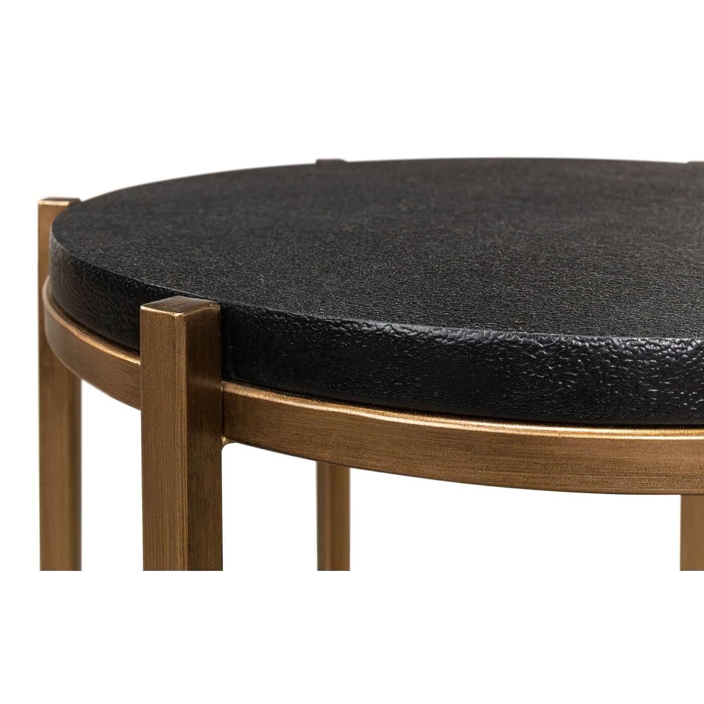 Table d'appoint moderne en cuir avec plateau rond gainé de cuir soutenu par une base à six pieds en métal doré avec un brancard.

Dimensions : 16