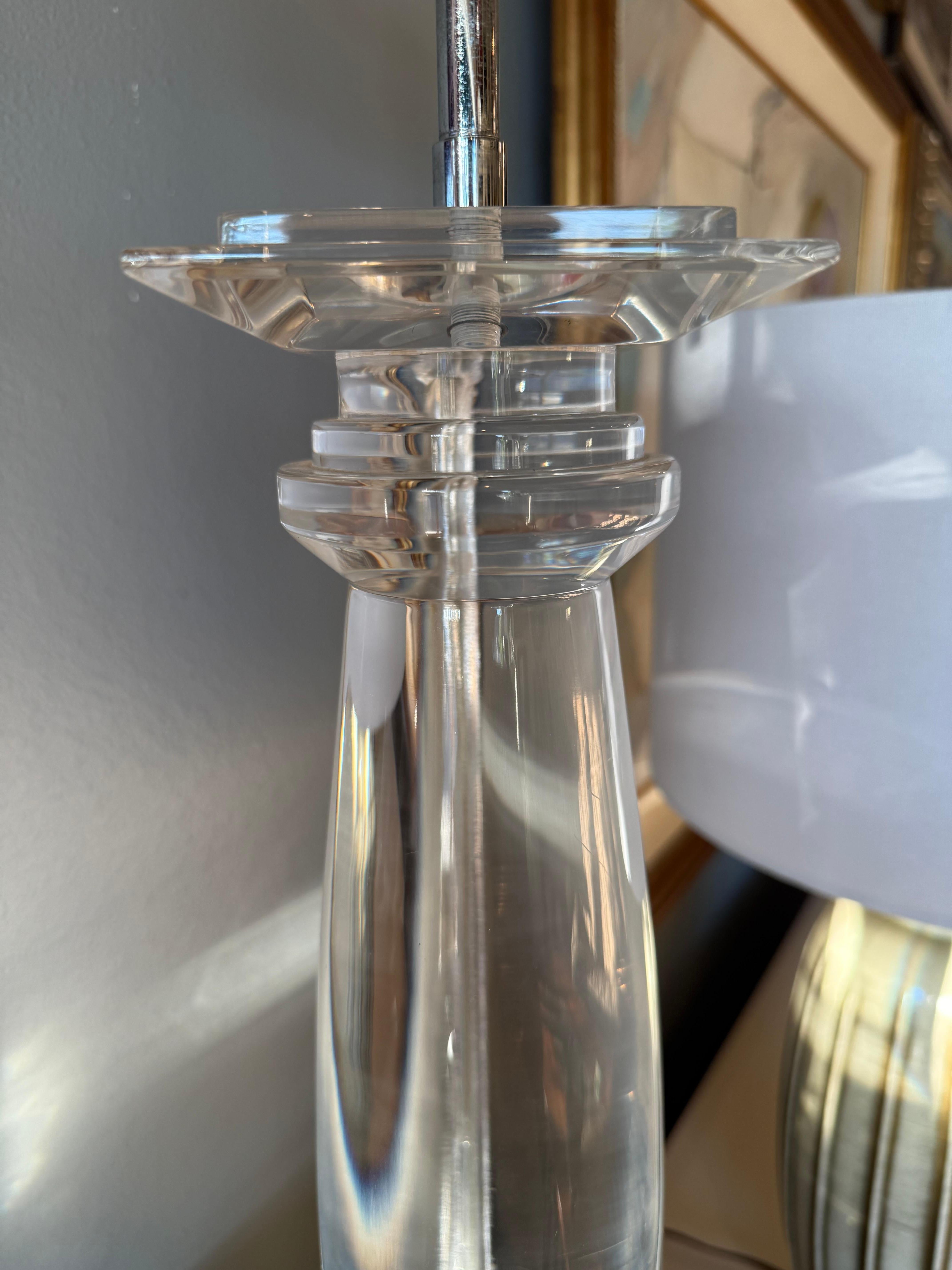 Este par de lámparas de mesa Lucite refleja la atrevida estética del diseño decorativo de los años setenta. Cada lámpara tiene una base columnar de lucita maciza, que se estrecha hacia arriba en una forma que recuerda a las columnas griegas clásicas