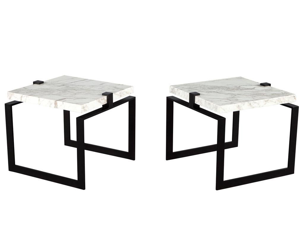Pair of modern marble and metal end tables. Custom made by the artisans at Carrocel in Toronto, Canada. Modern powder coated black cubed frames with floating off-white marble tops with beautiful gray and beige veining. The perfect combination of