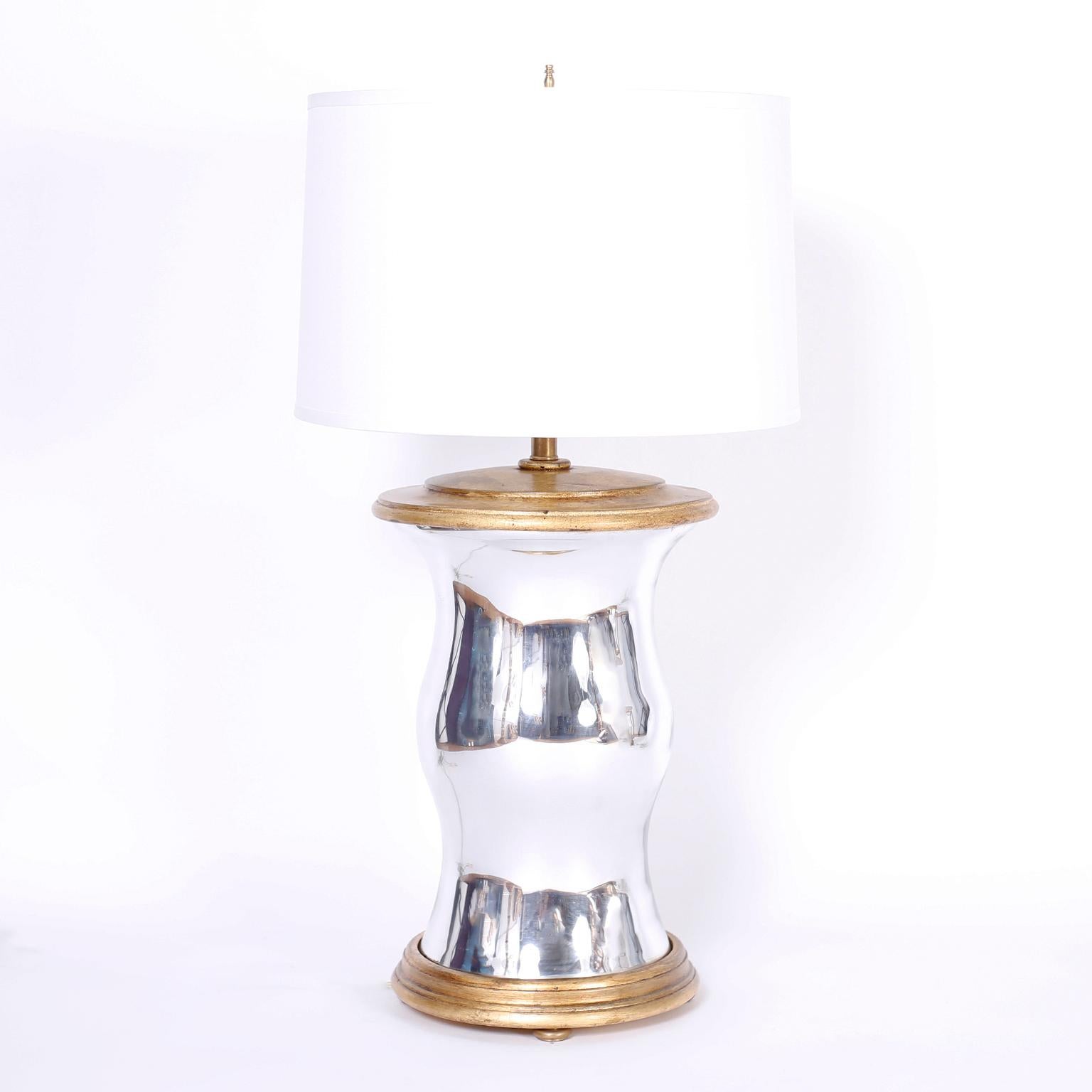 Large scale stand out pair of modern table lamps with mirrored glass bodies in the form of hurricane globes and gilt wood caps and bases with pad feet.