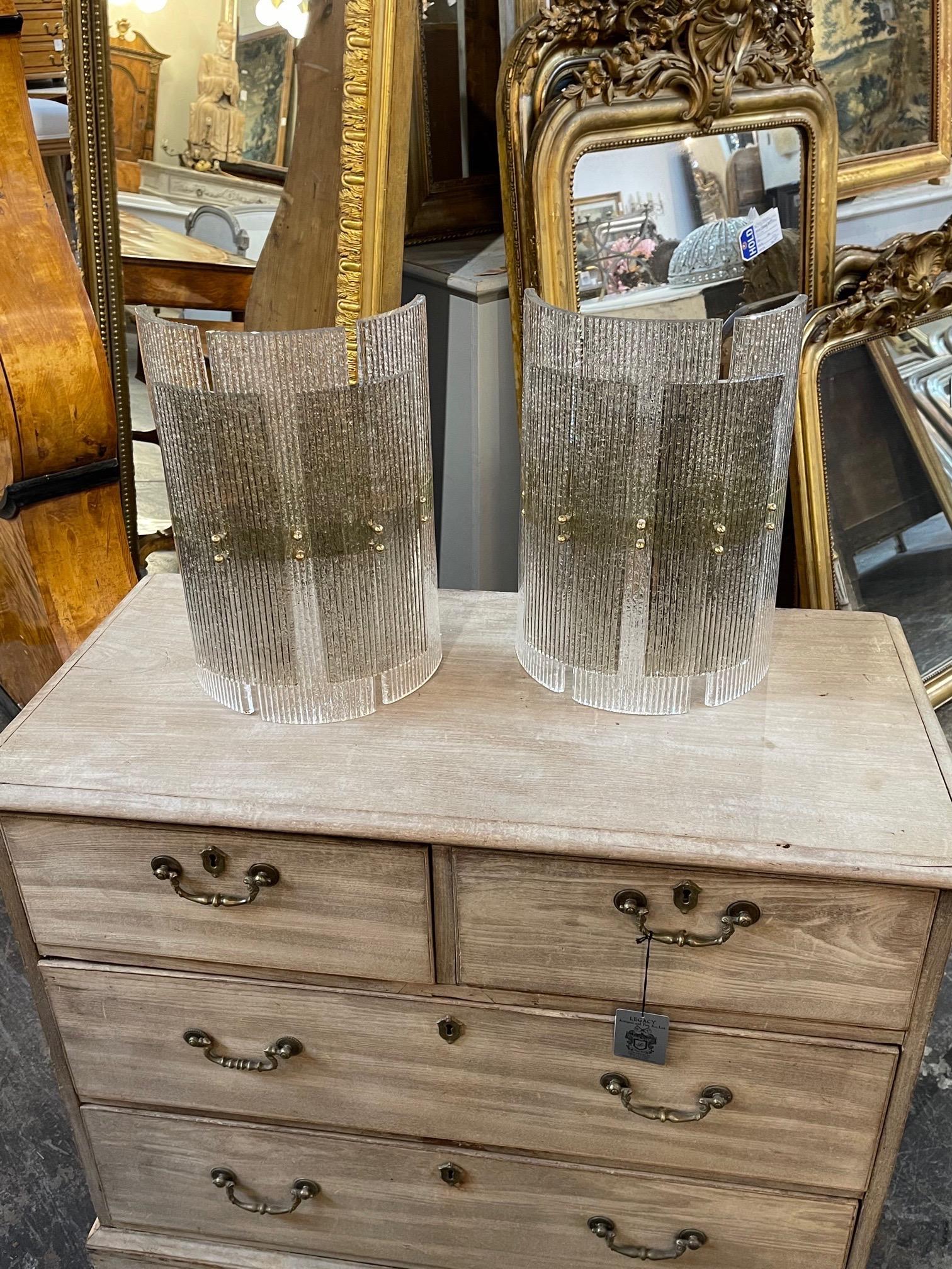 Elegant pair of modern Murano glass layered wall sconces. The bottom layer is clear and the top layer has a slight gold tone. So beautiful! A lovely textural element!