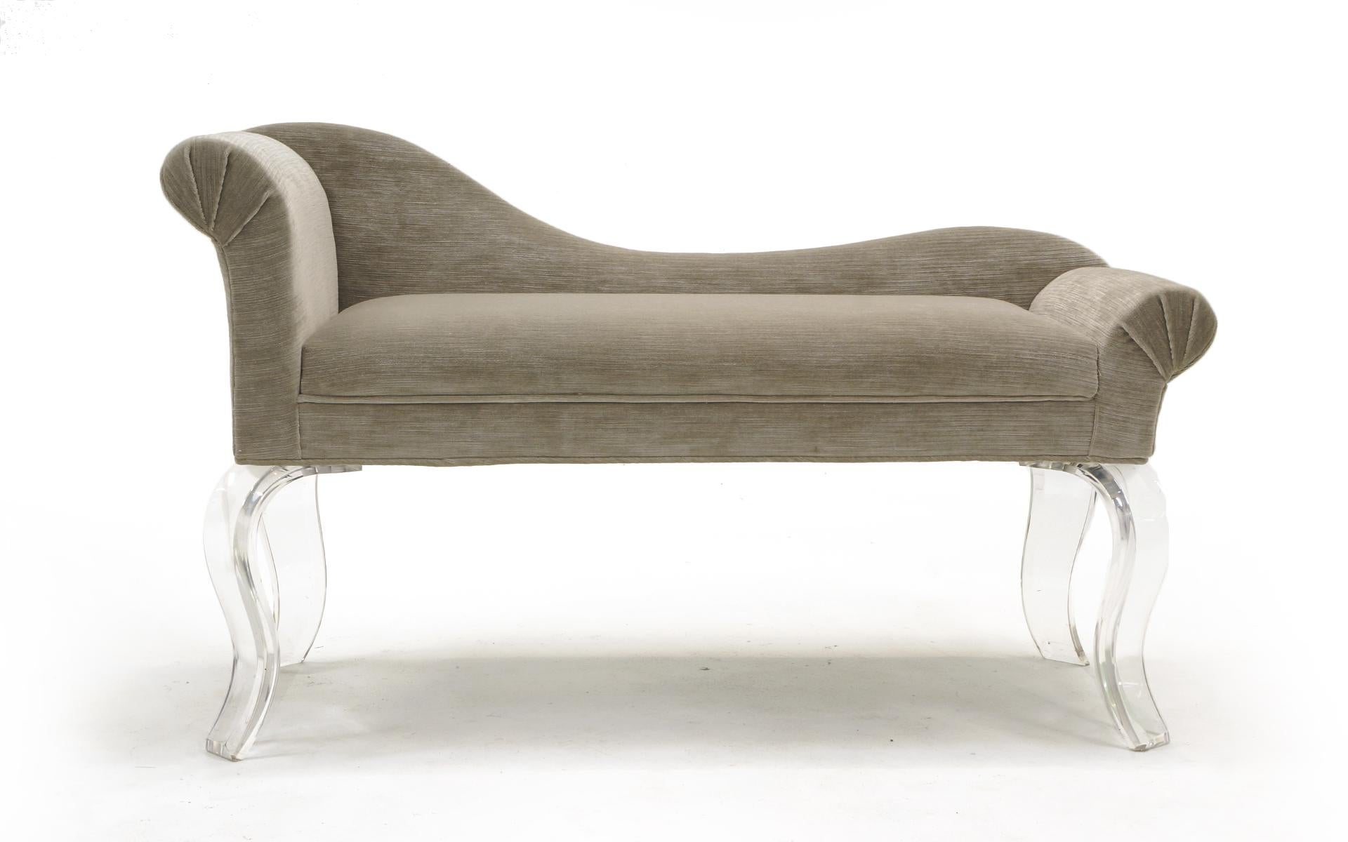 Pair of Recamiers with new gray upholstery and thick, substantial acrylic legs. These are smaller scale, mostly backless with a higher headrest on one end. Can also seat two as a settee or loveseat. A subdued elegance. Expertly reupholstered and