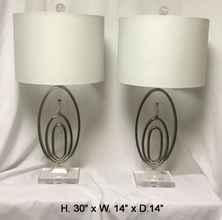 Pair of modern style rock crystal lamps, late 20th century. 
A modern style lamp with an oval forged and chromed metal enhanced with a hand-carved and polished rock crystal sphere and finial, raised on rock crystal and clear rectangular