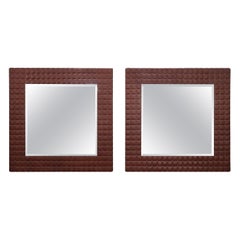 Paire de miroirs de style moderne tapissés, en verre biseauté et touffeté