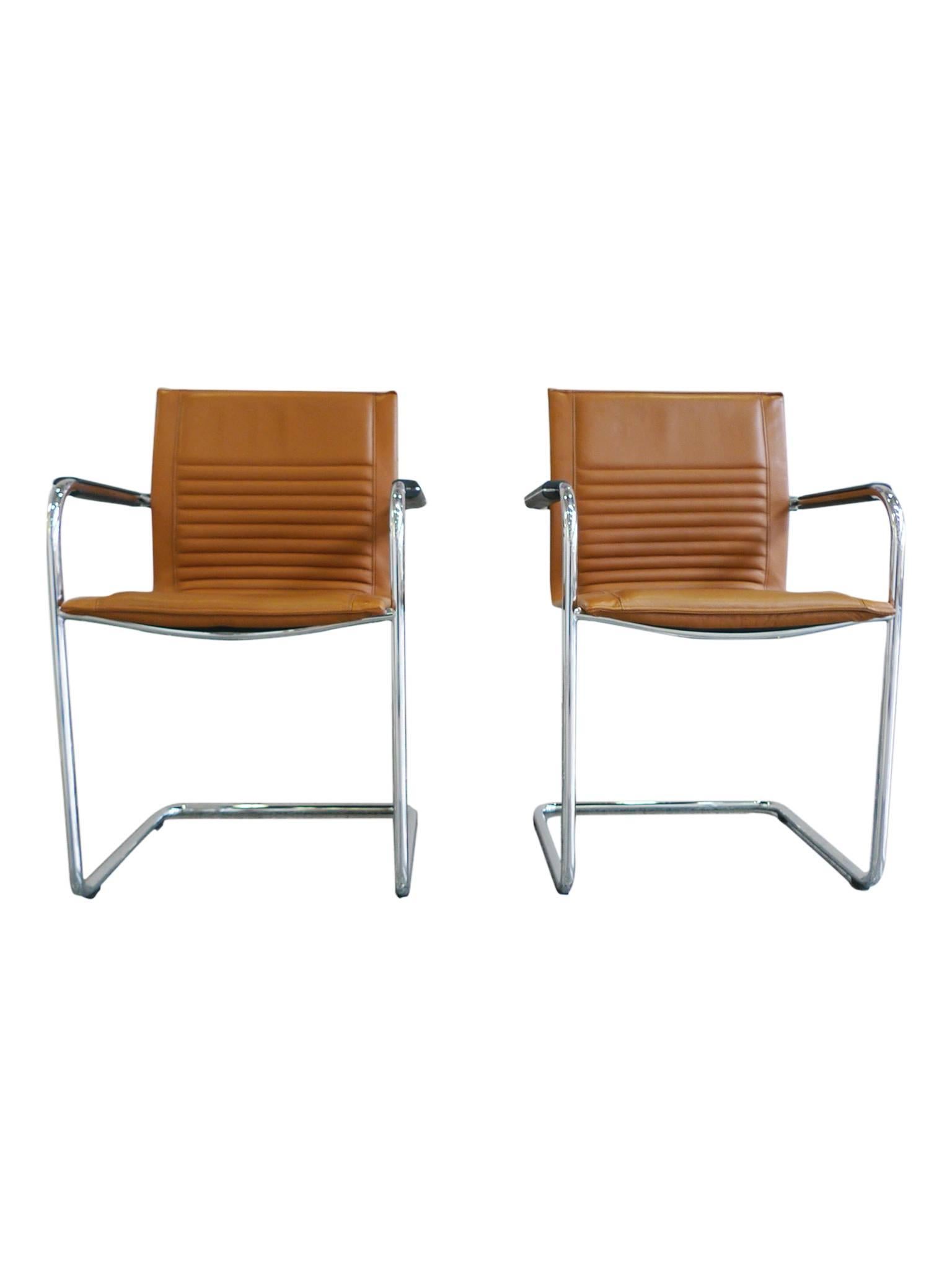 These two armchairs are designed by Haworth Design Studio. They are comprised of a cantilevered tubular chrome frame and leather upholstery. Their structure and technique are in the manner of Mart Stam and his contemporaries: minimal with straight