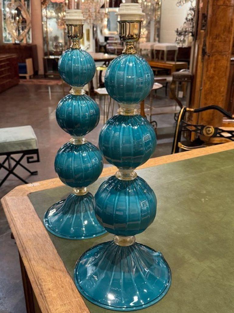 Ce produit est une paire de lampes modernes en verre Murano de couleur sarcelle qui ajoutent une touche d'élégance à n'importe quelle pièce. Le design en forme de boule dans une couleur bleue vibrante.  crée un look contemporain et élégant. Ces