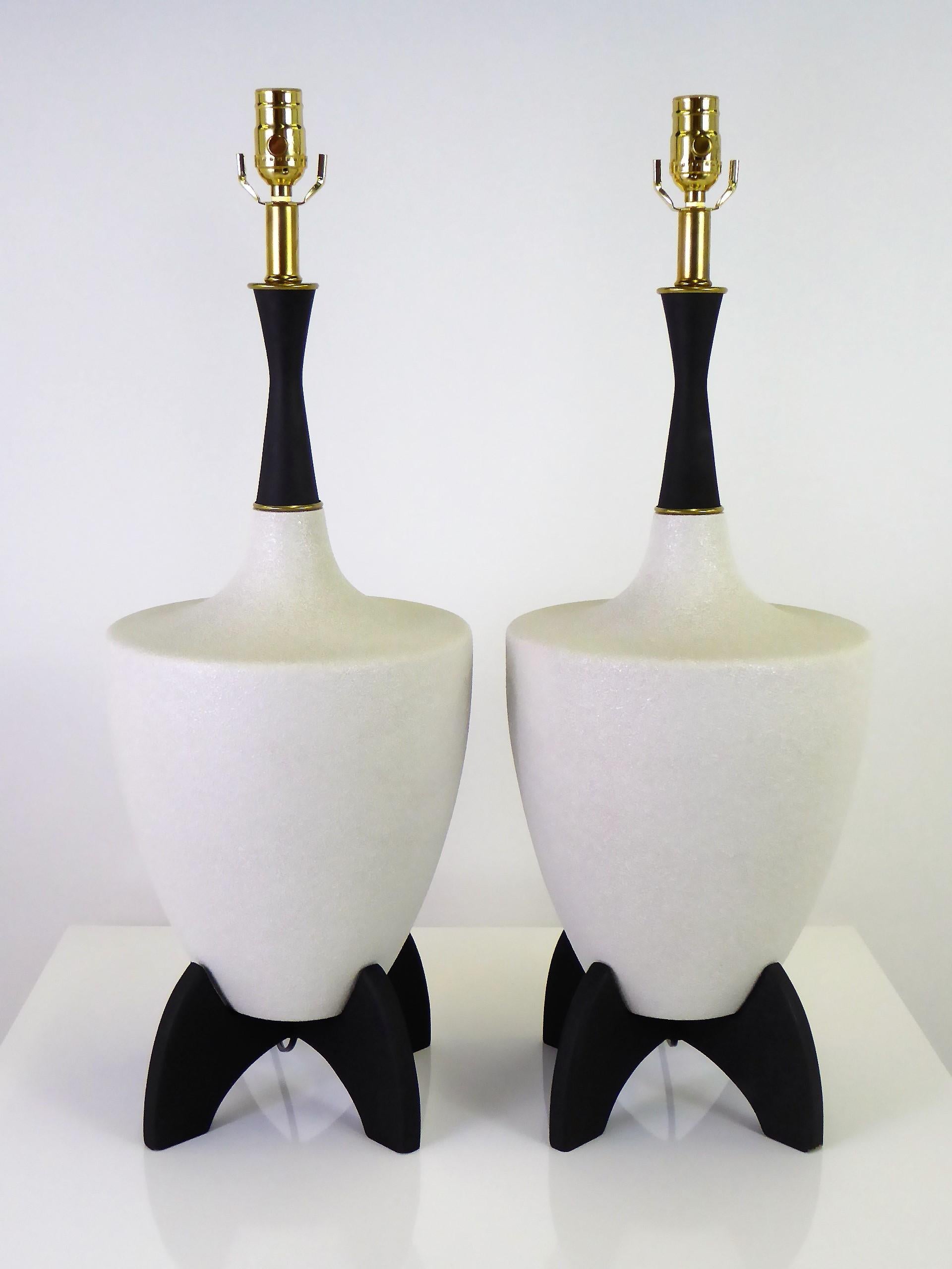 Mid-Century Modern pair of urn shape cream color pebble glaze ceramic with black wooden stand and neck table lamps, 1950s. With brass accents, the lamps have been fully restored, rewired and with new brass UL three level sockets. Takes medium base