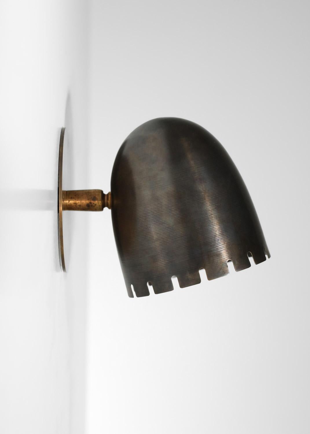 Ces appliques présentent une structure et un abat-jour en laiton massif, avec une patine semblable à celle d'un fusil (de légères nuances de patine peuvent apparaître en fonction du bain). L'abat-jour est monté sur une rotule décorative en laiton. 
