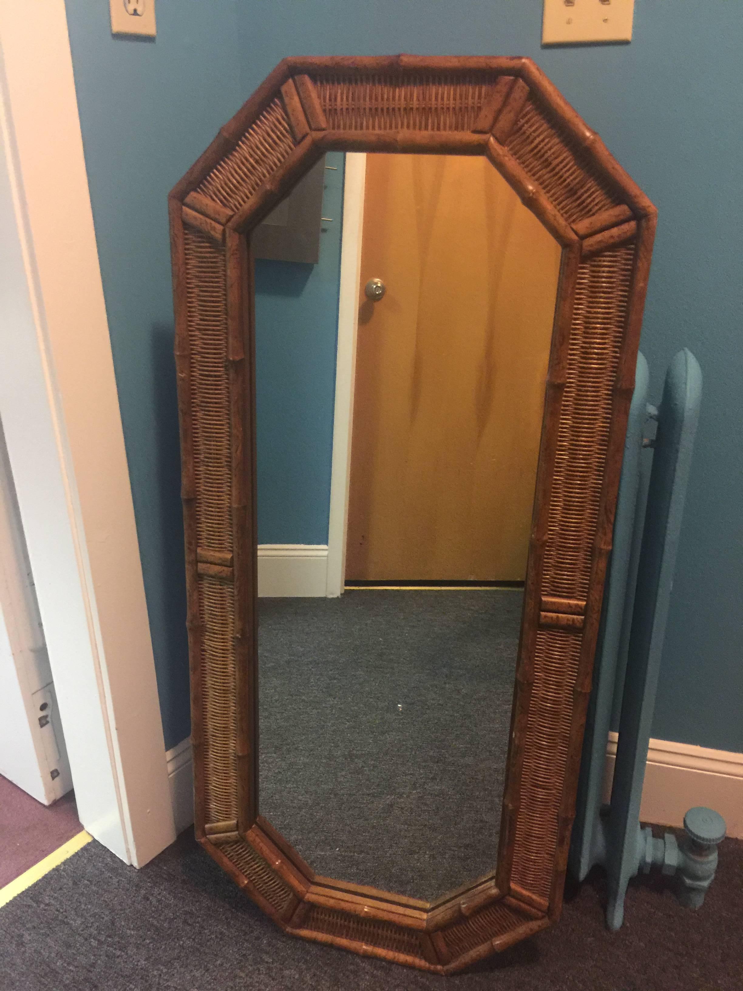 Matched pair of 1970s wicker and wood bamboo elongated octagonal wall mirrors. These are substantial in form and construction.