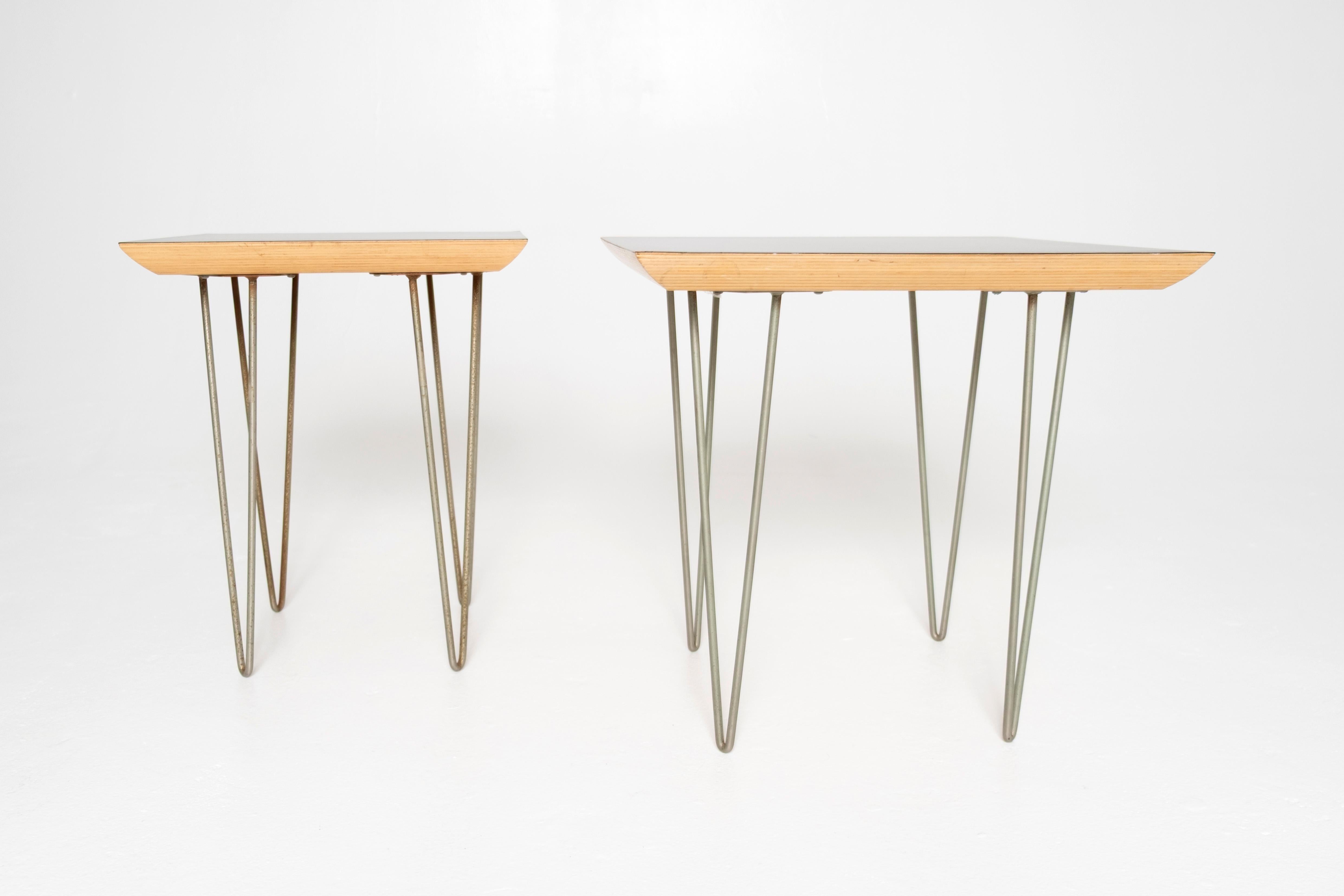 This pair of Modernica side tables embodies clean-lined American modernism with a nod to mid-century design. Each table features a black laminate top with gently radiused edges, set on raw steel hairpin legs that provide a minimalist yet industrial