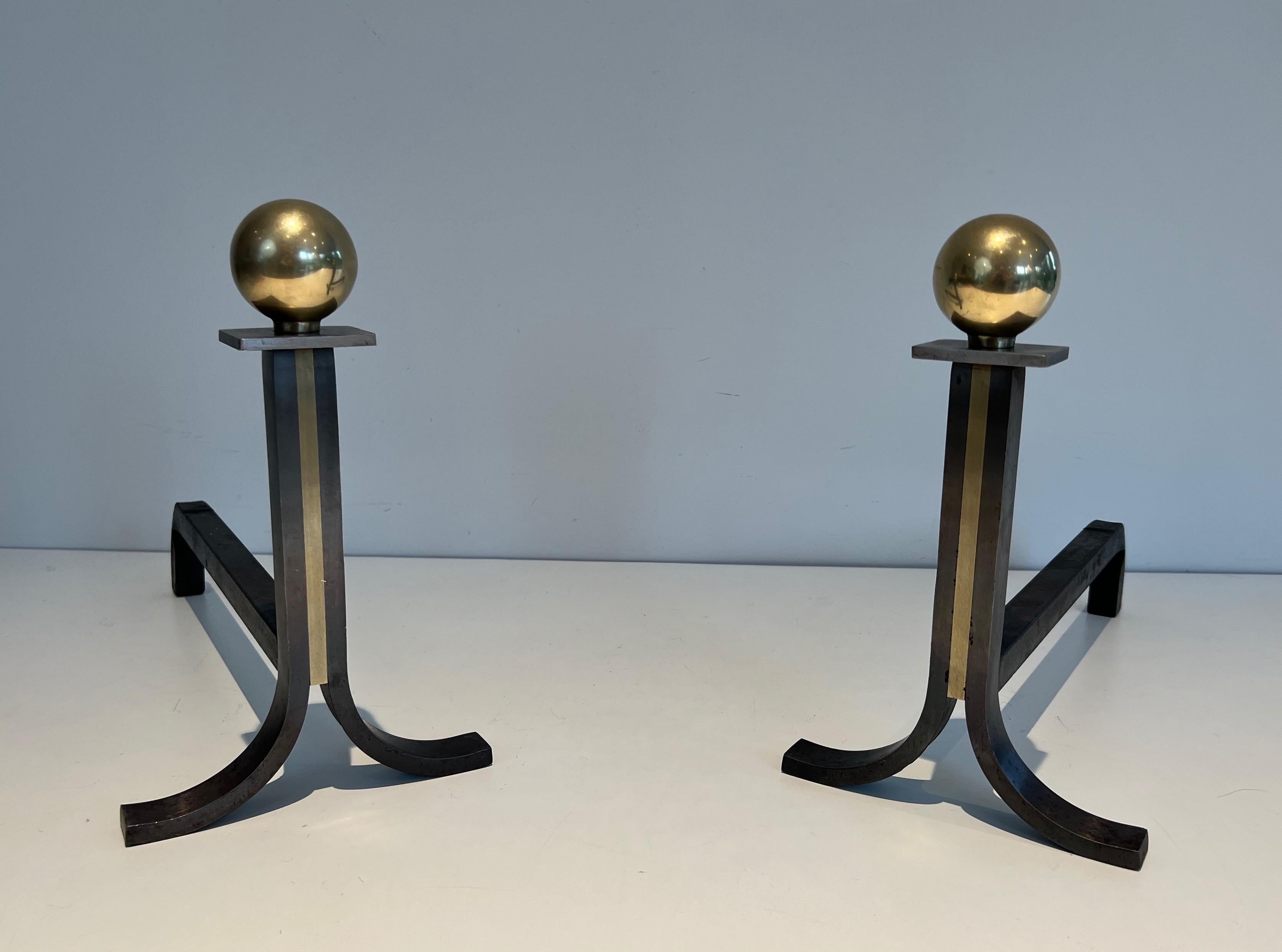 This pair of modernist andirons is made of wrought iron, brass and cast iron. This is a work in the style of famous French designer Jacques Adnet. Circa 1940.