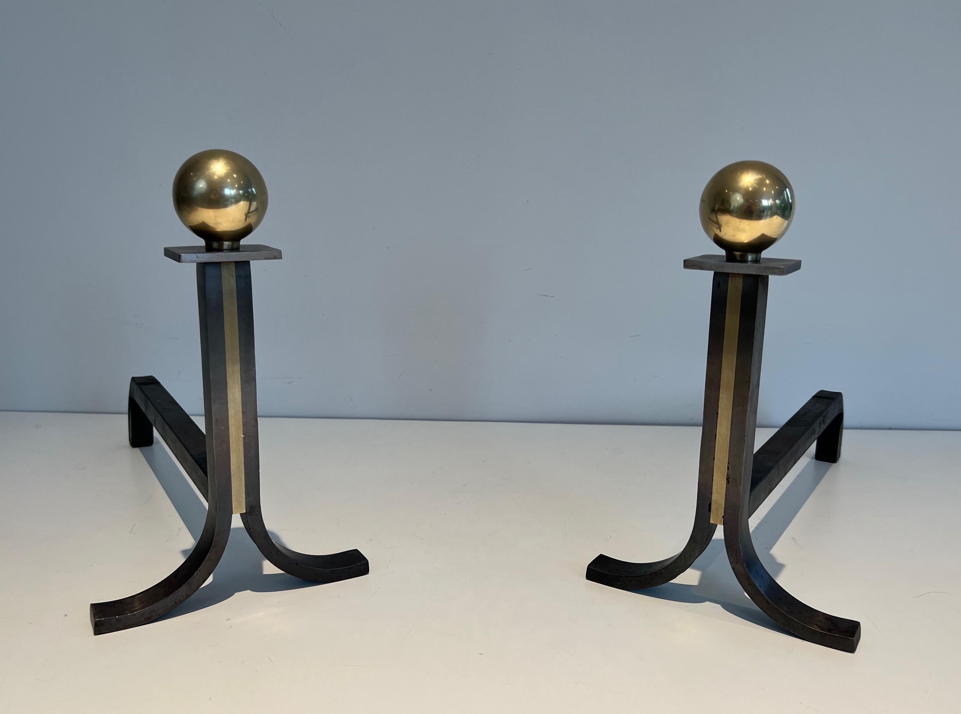 Dieses Paar modernistischer Andirons ist aus Schmiedeeisen, Messing und Gusseisen gefertigt. Dies ist ein Werk im Stil des berühmten französischen Designers Jacques Adnet. Ca. 1940.