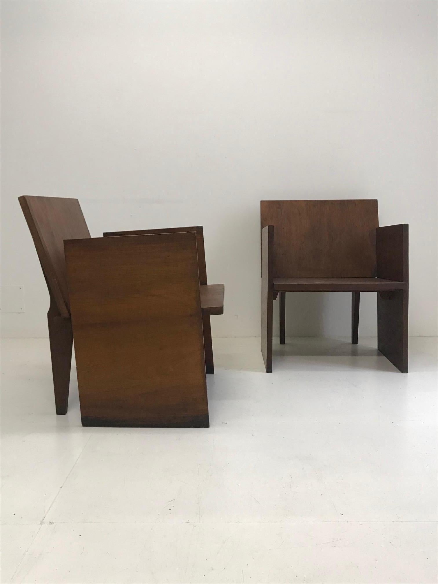 This pair of modernist armchairs is amazing of modernity and creativity! 
The designer is not identified, but it is a real piece from the modernist period. The wood is a very dense and heavy massive mahogany. The wood was worked by hand and not by