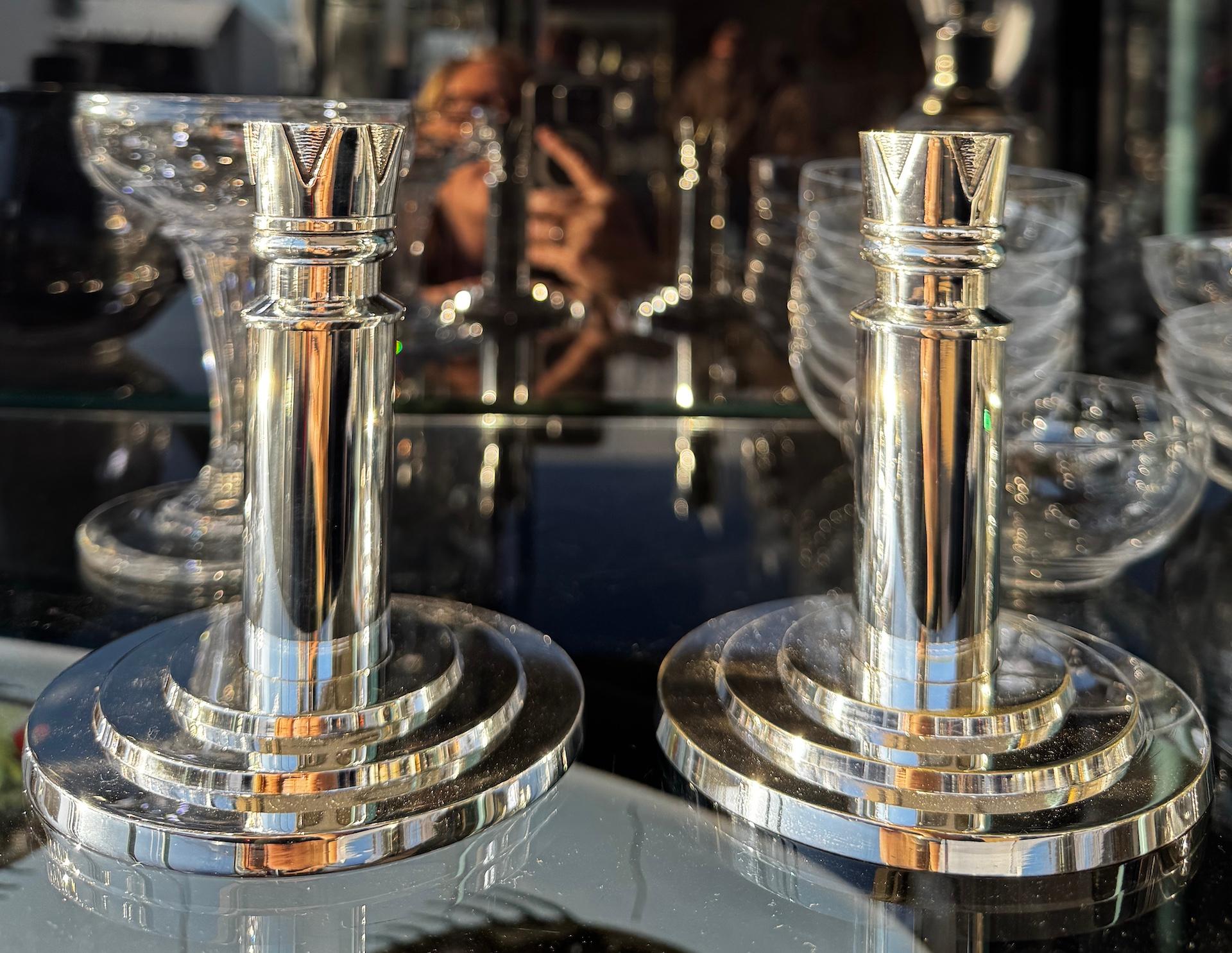 Pair of modernist Art Deco Candlesticks by the ever famous French Ercuis Company in Silver Plated Metal.

A very sleek design of candlestick, circa 1930, with a stepped circular base, a smooth and shiny barrel topped with a delicate hammered metal