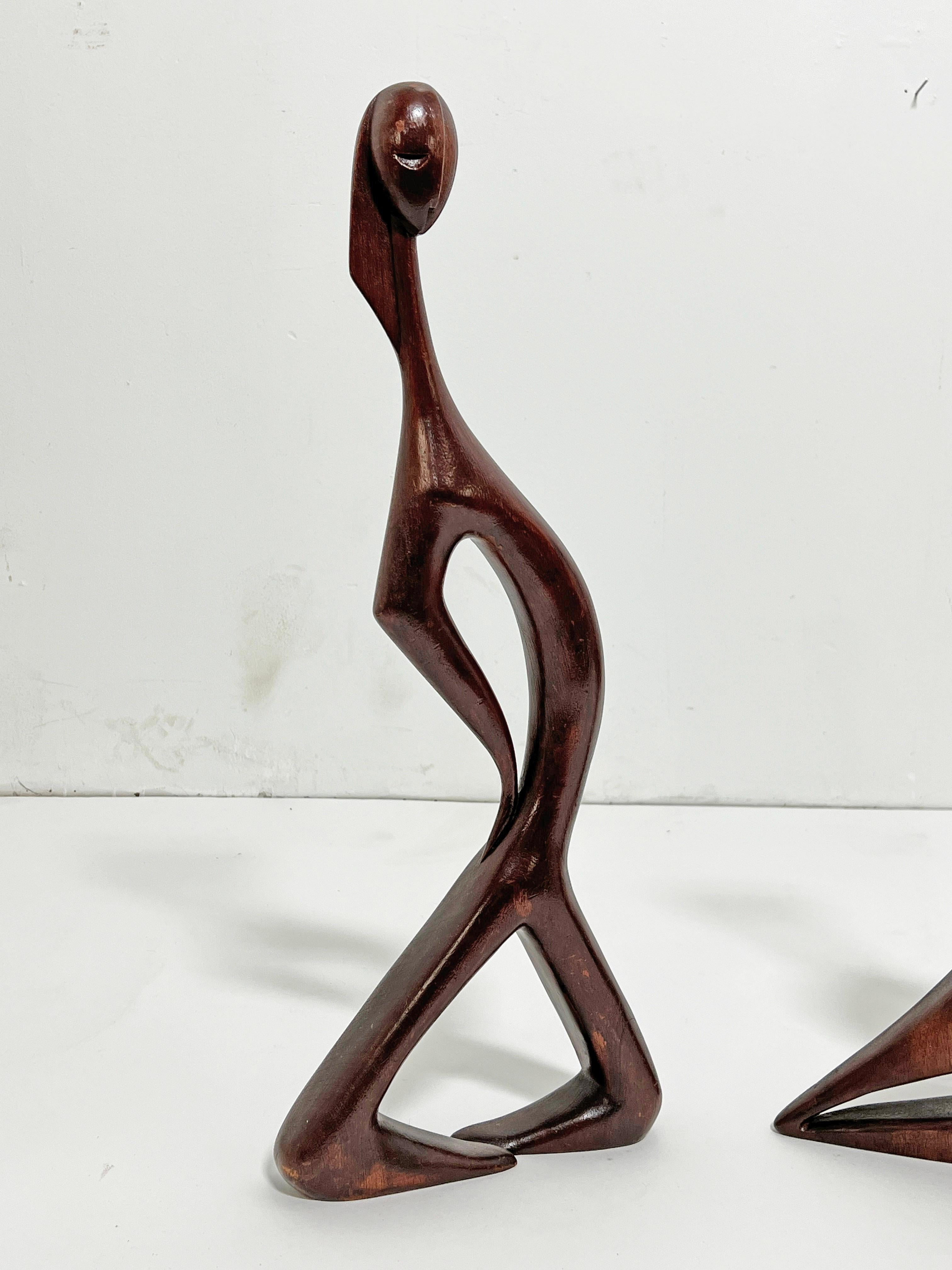  A rare pair of carved mahogany abstract figures circa mid-1950s by the modernist jeweler and painter Stella Popowski (1931-2008). Popowski was active in both Los Angeles and San Francisco, California and an important figure in the modernist jewelry