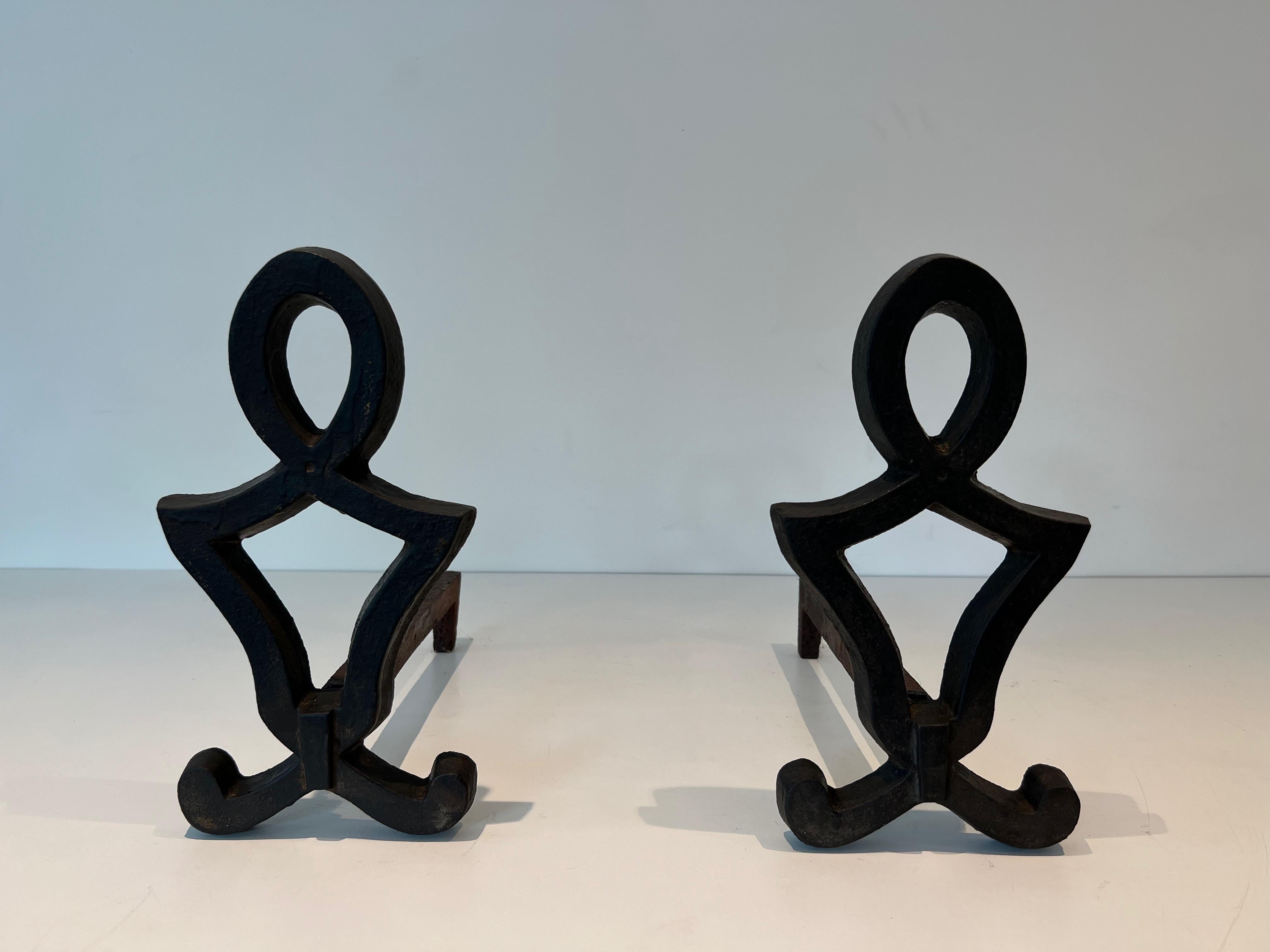 This pair of modernist andirons is made of cast iron and wrought iron. This is a French work by Raymond Subes. Circa 1940