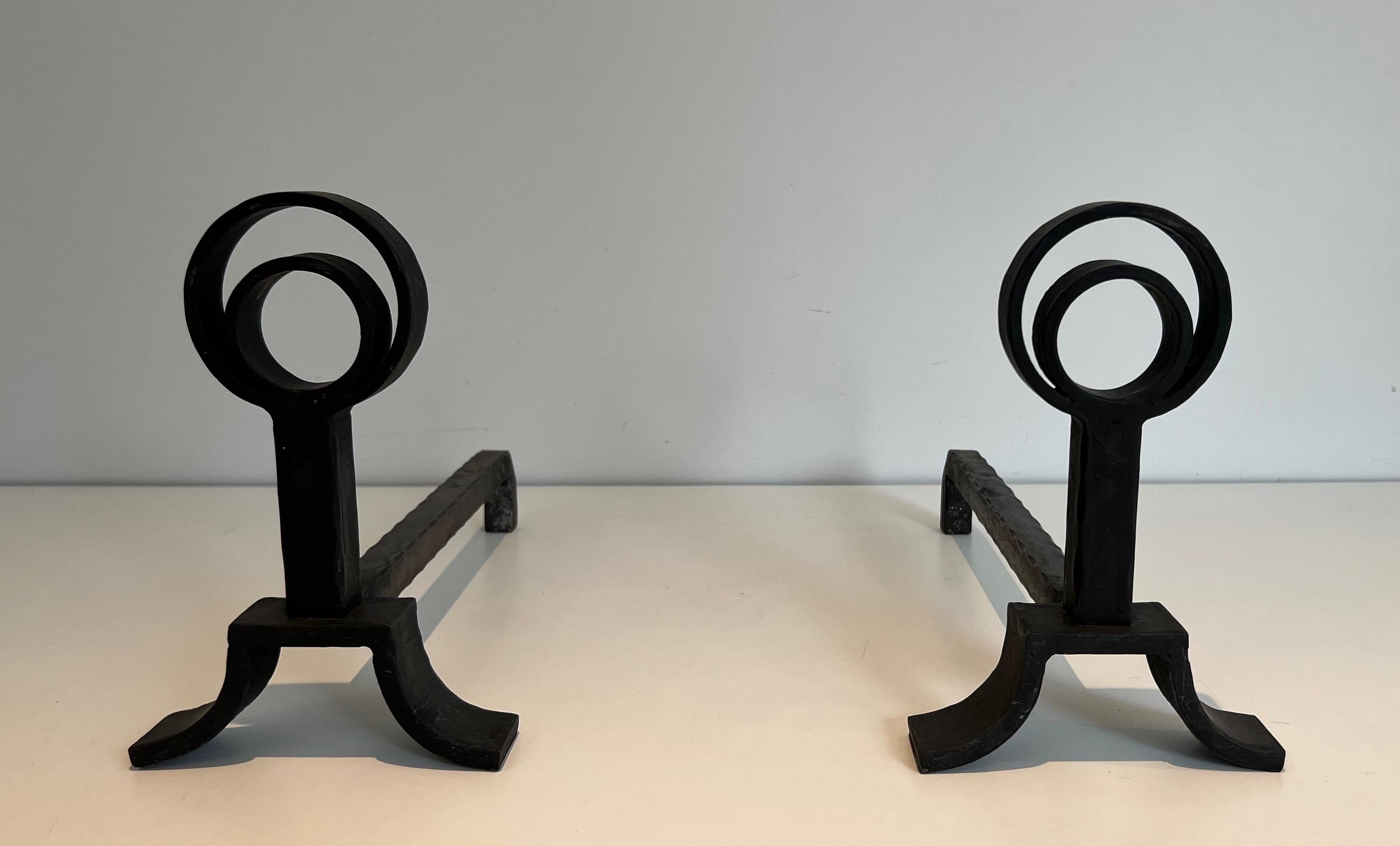 This pair of modernist andirons is made of wrought iron. This is a French work in the style of Jacques Adnet. Circa 1940.