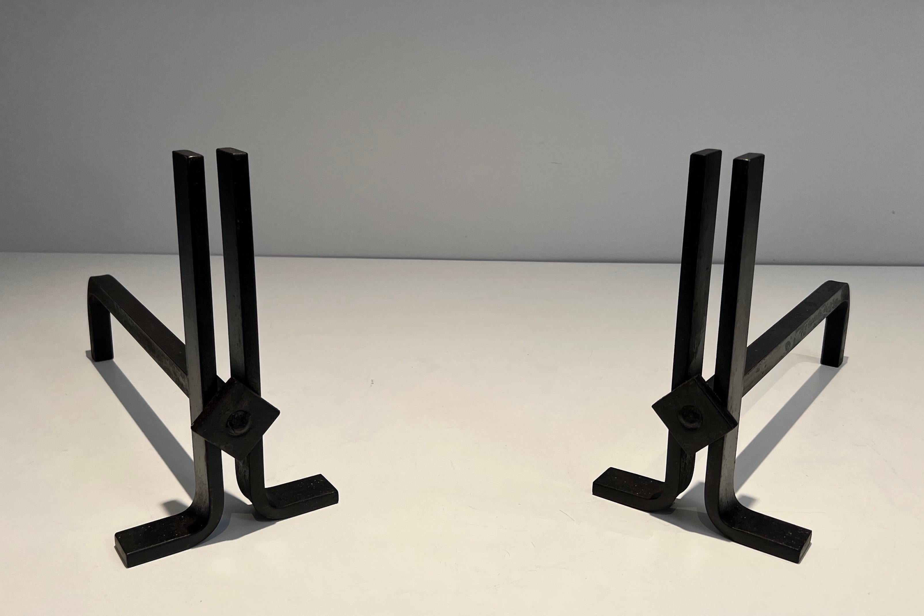 This pair of modernist andirons is made of iron and wrought iron. This is a French work, circa 1940.