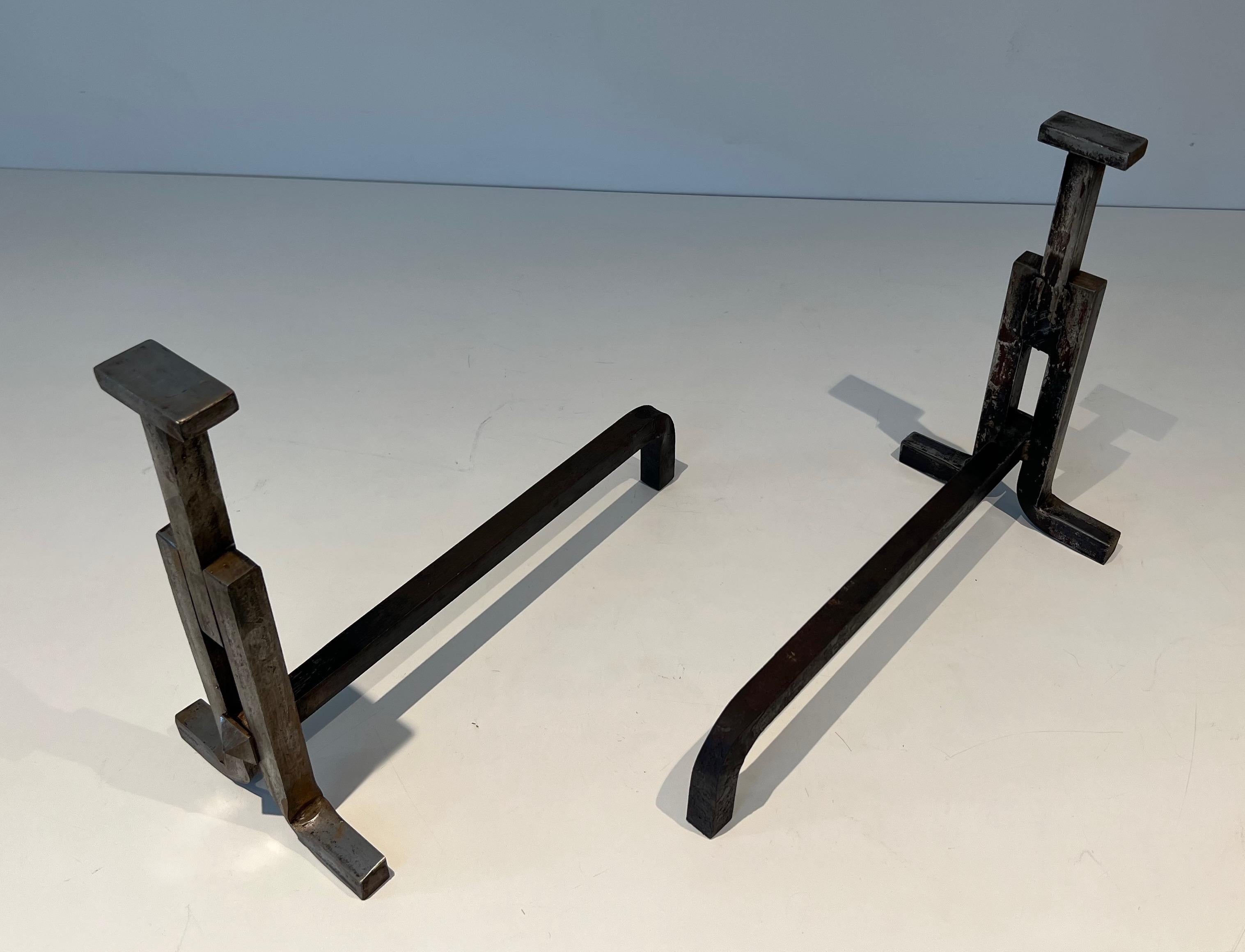 This pair of modernist andirons is made of wrought iron. This is a French work. Circa 1950