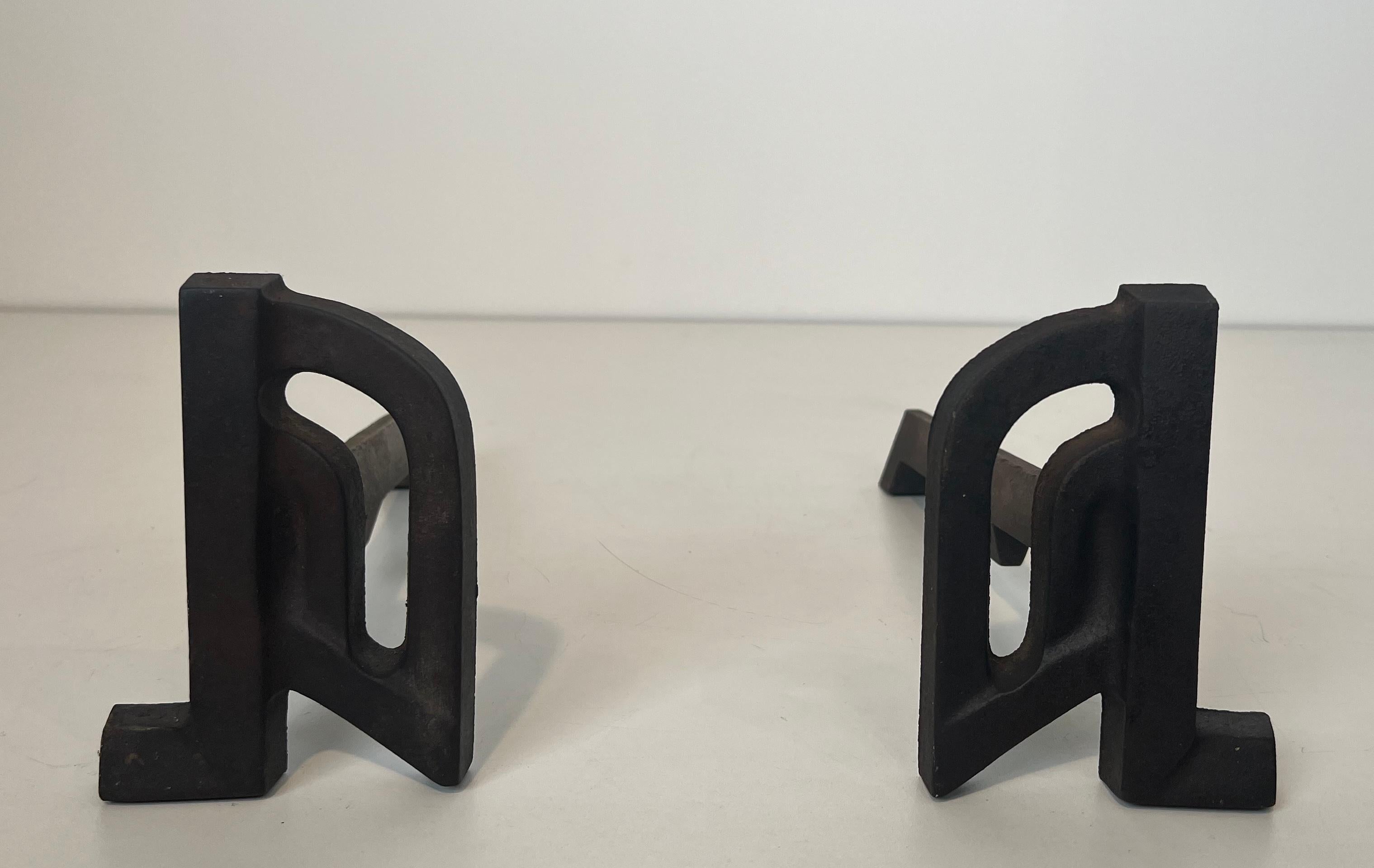 This pair of modernist andirons is made of cast iron and wrought iron. This is a French work. Circa 1940