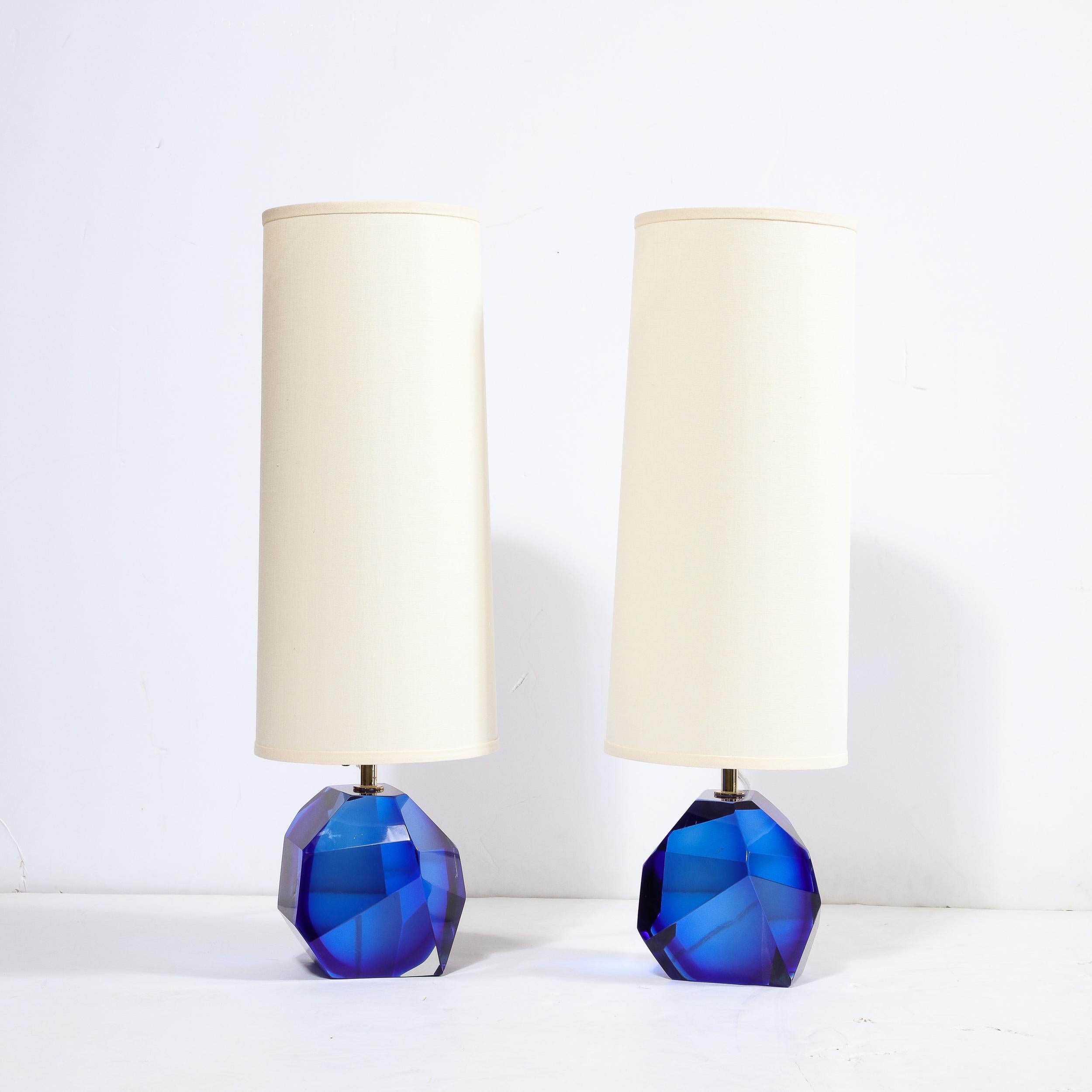 This striking and elegant pair of table lamps were handblown in Murano, Italy- the islands off the coast of Venice renowned for centuries for their superlative glass production. They feature faceted bodies realized in handblown translucent Murano