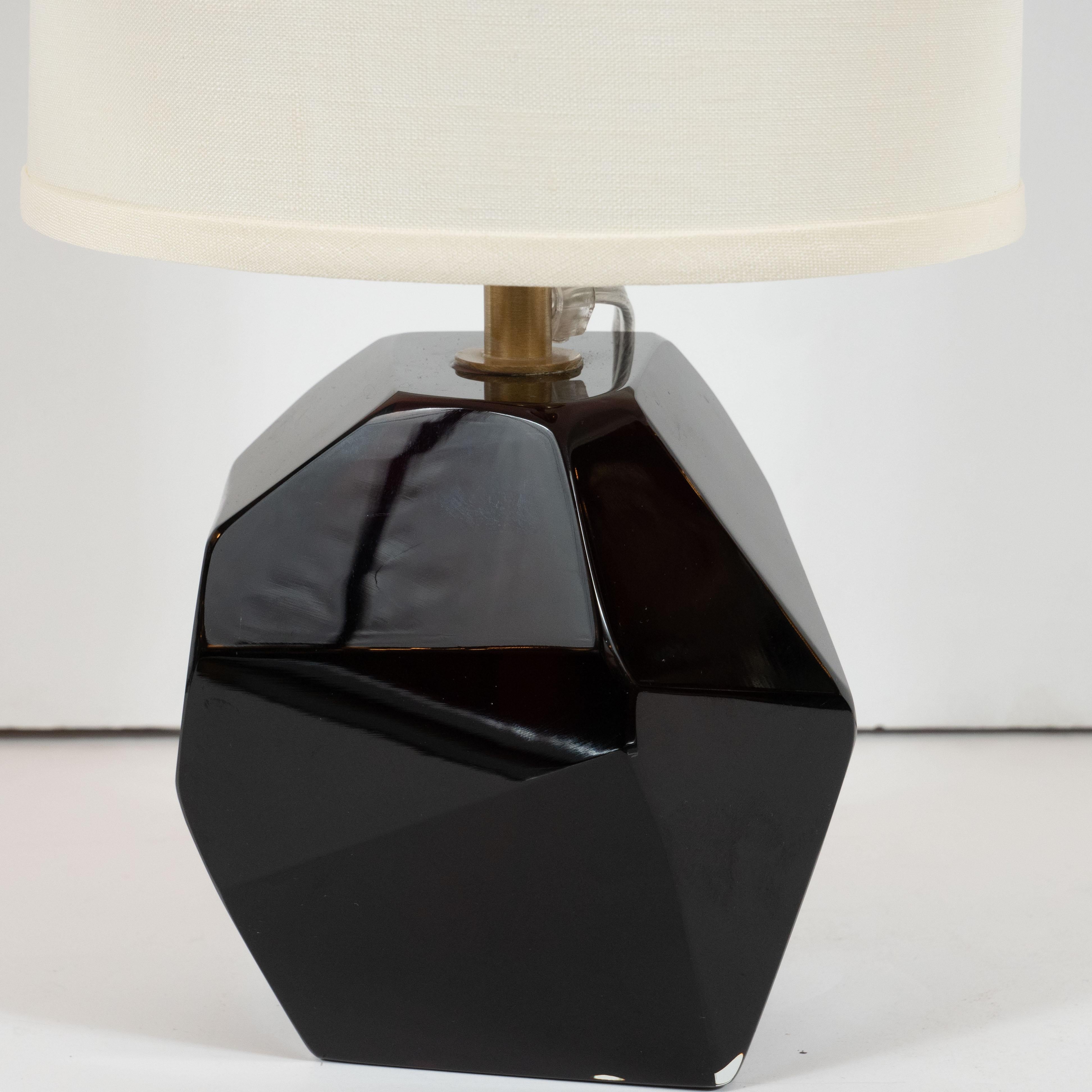 This stunning and elegant pair of table lamps were realized in Murano, Italy- the island off the coast of Venice renowned for centuries for its superlative glass production. They feature faceted bodies- like oversized cut gemstones- in a gorgeous
