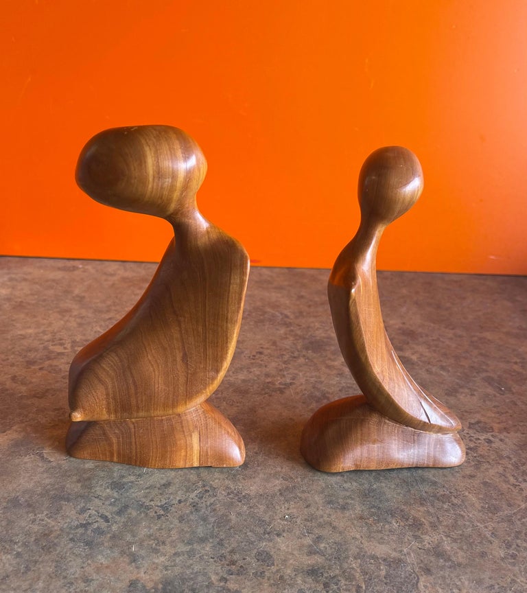 Super cool pair of modernist figural sculptures in burlwood, circa 2000s. The figures are hand carved and measure: 7.5