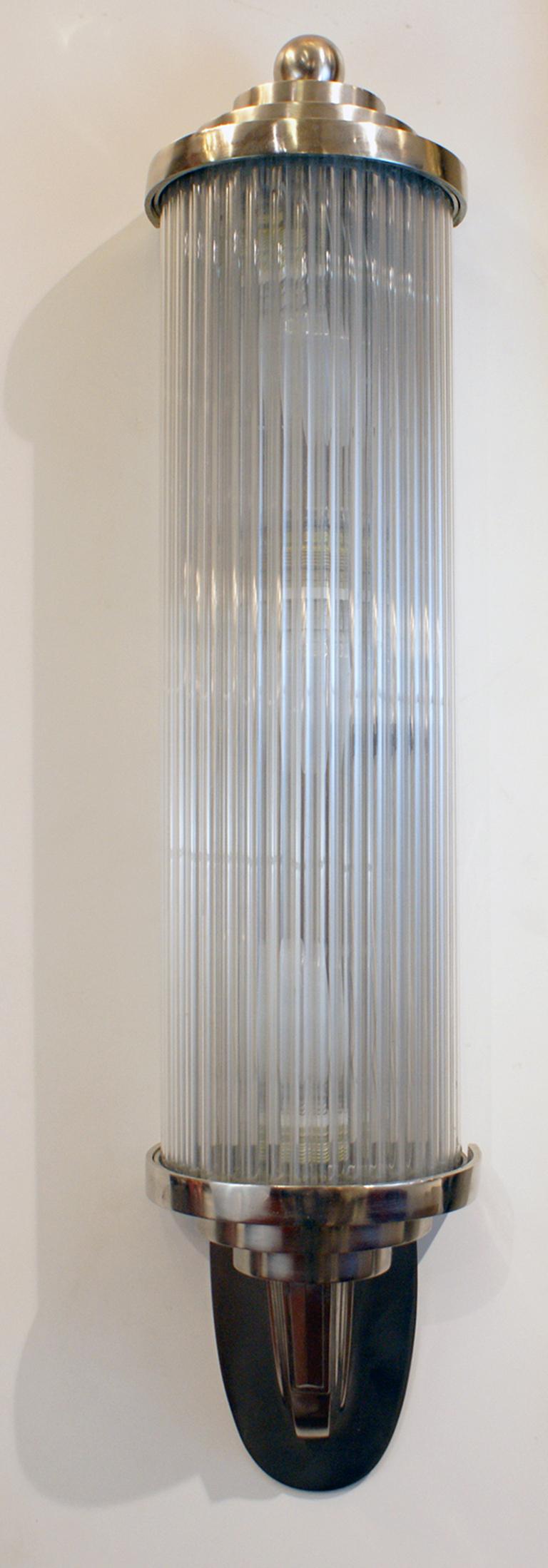 Pair of modernist French Art Deco wall lights, featuring long solid clear glass tubular rods that forms a semi-cylinder shape, held by nickel plated bronze frame with geometric design. Can be hang in vertical or horizontal position.
Having three